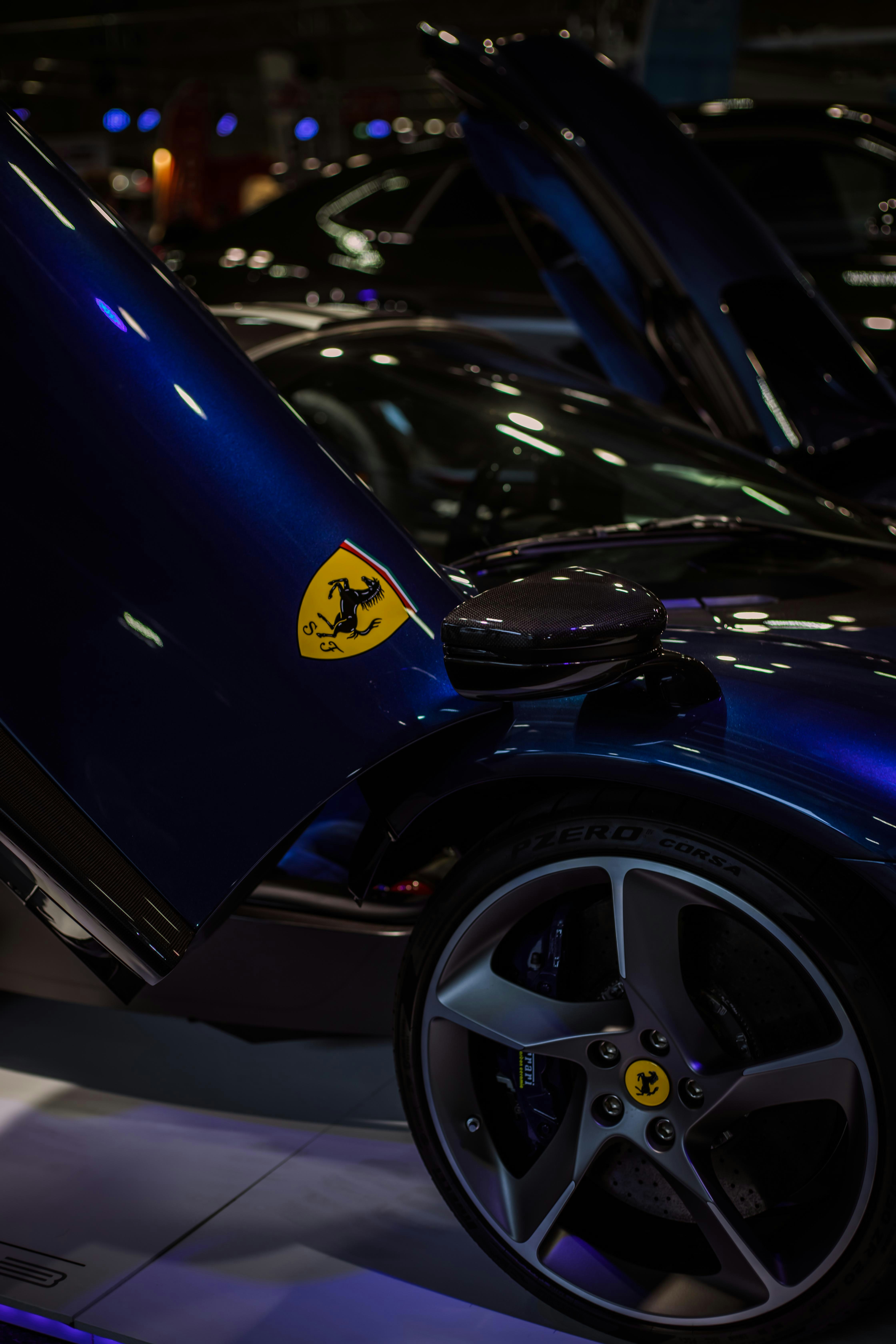 Blue ferrari with doors open and emblem visible