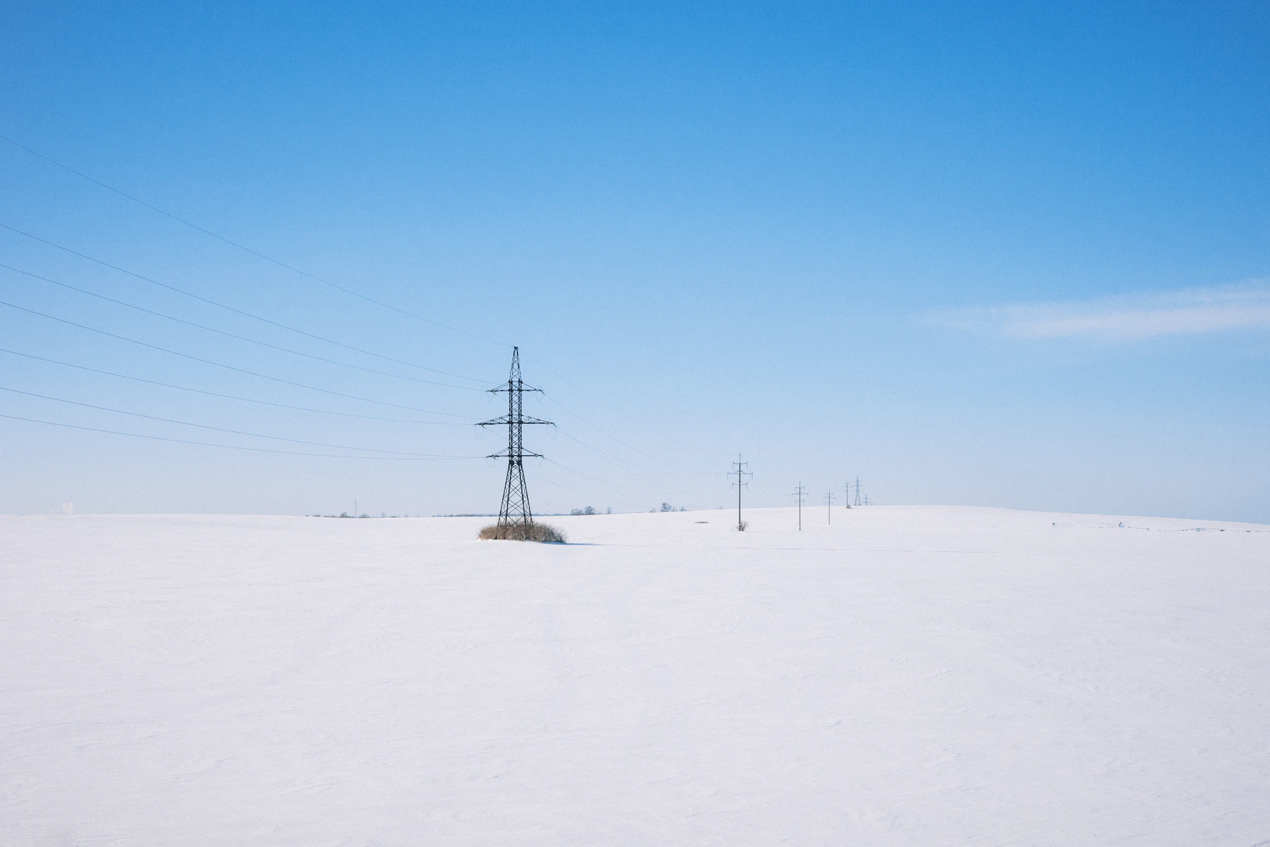 Electric transmission infrastructure operating across a snow-covered winter landscape