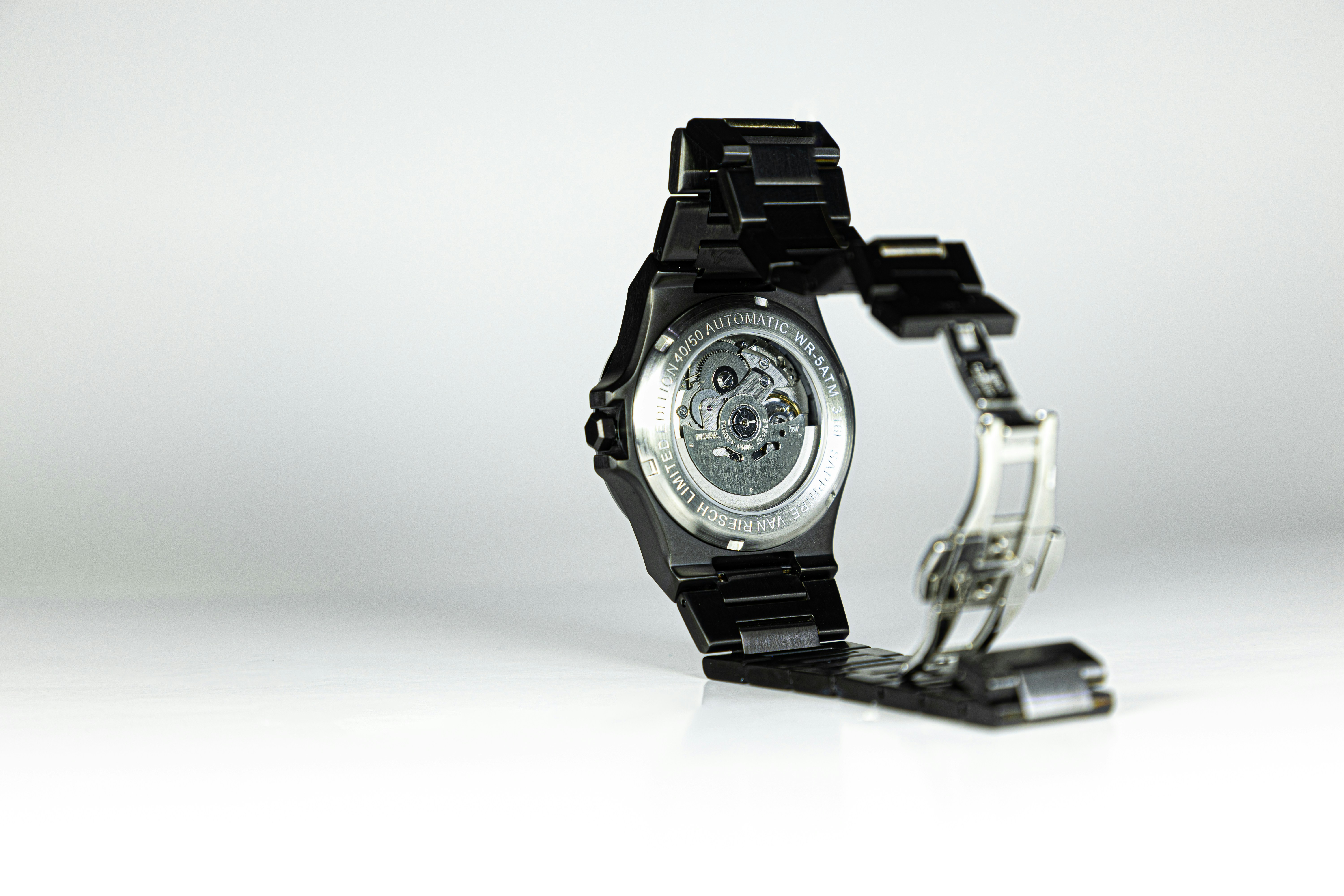 Close-up of a black wristwatch with open clasp