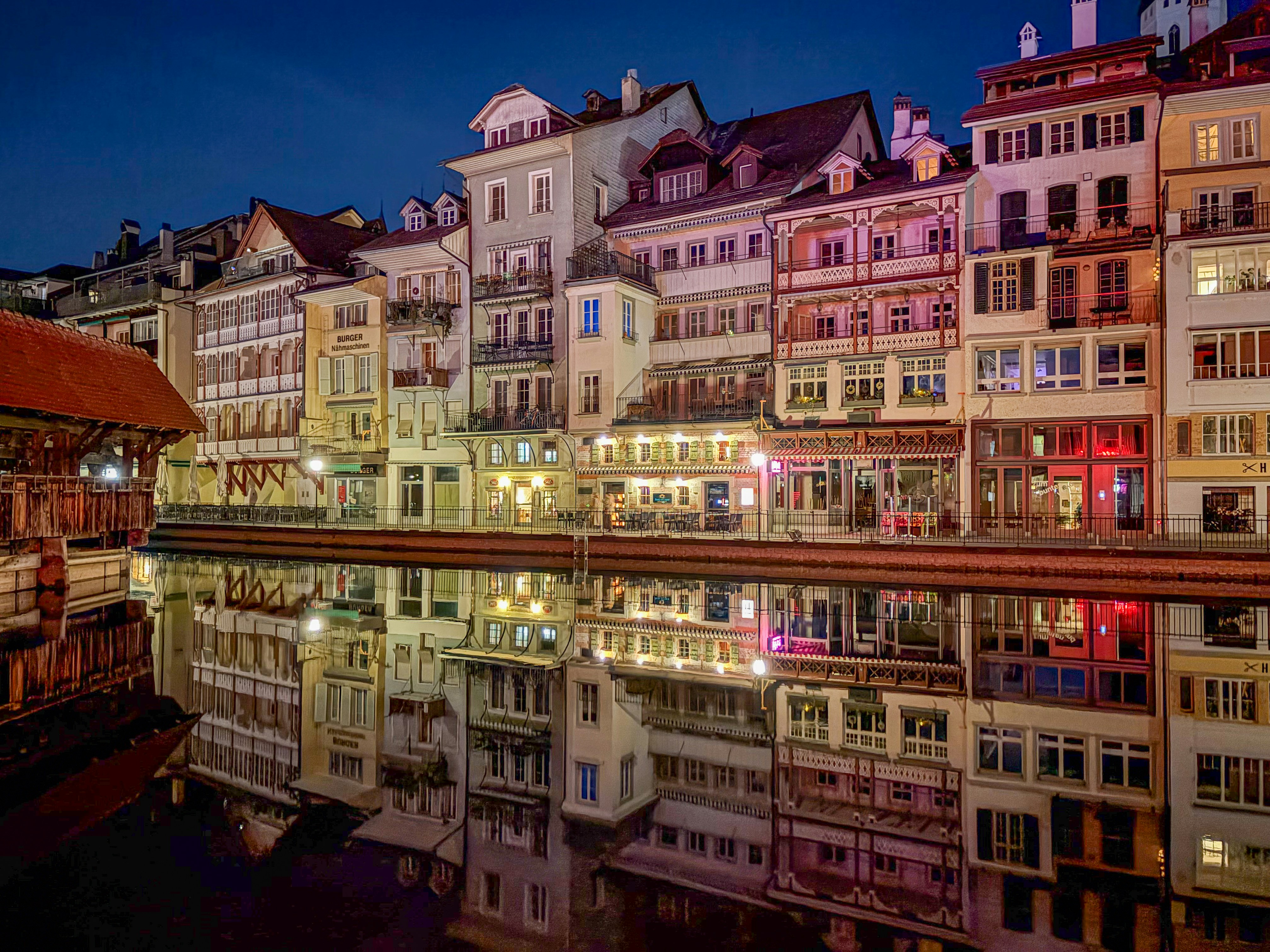 Colorful buildings reflected in water at dusk.