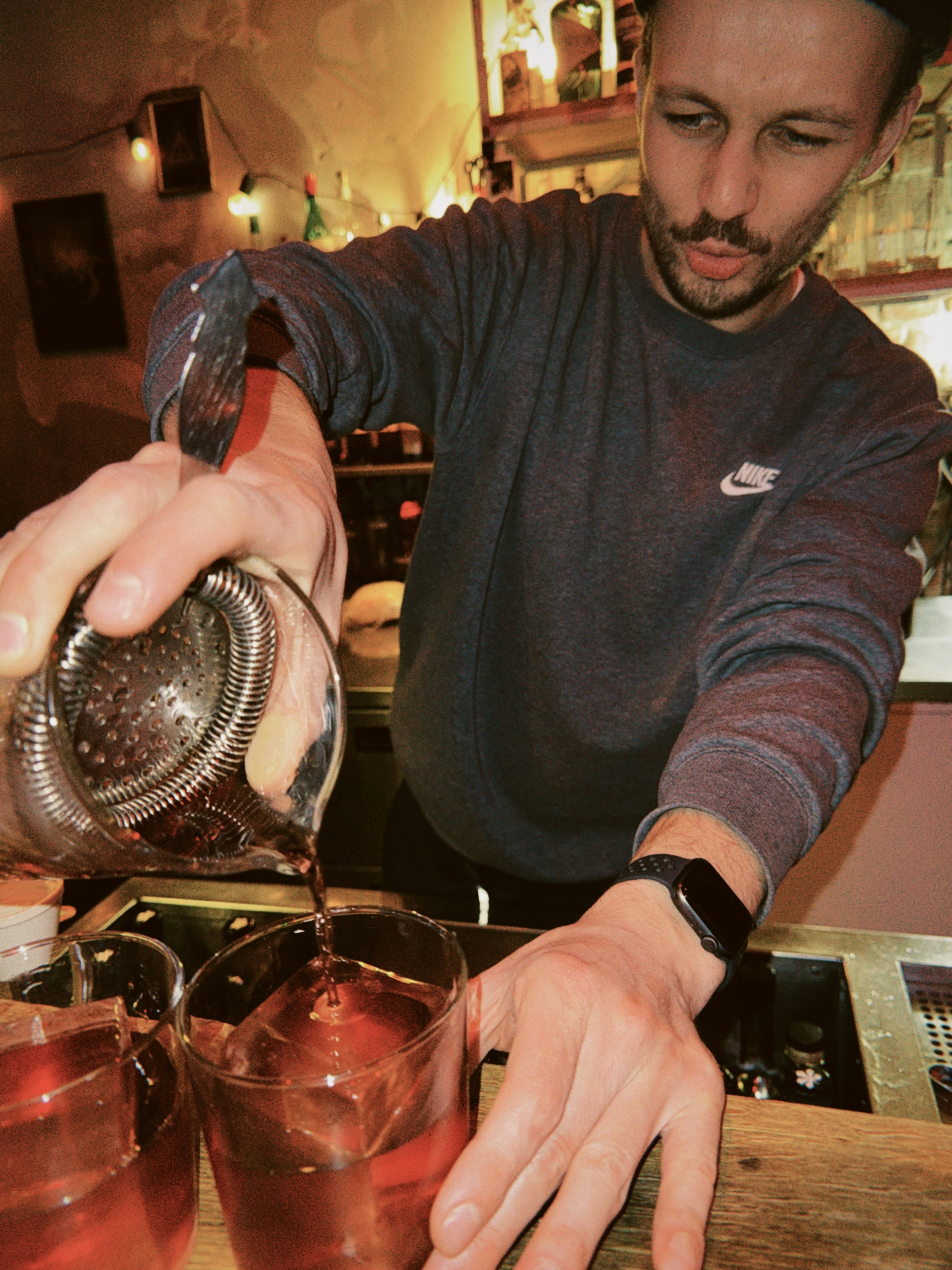 Barkeeper gießt ein Getränk in ein Glas mit Eis