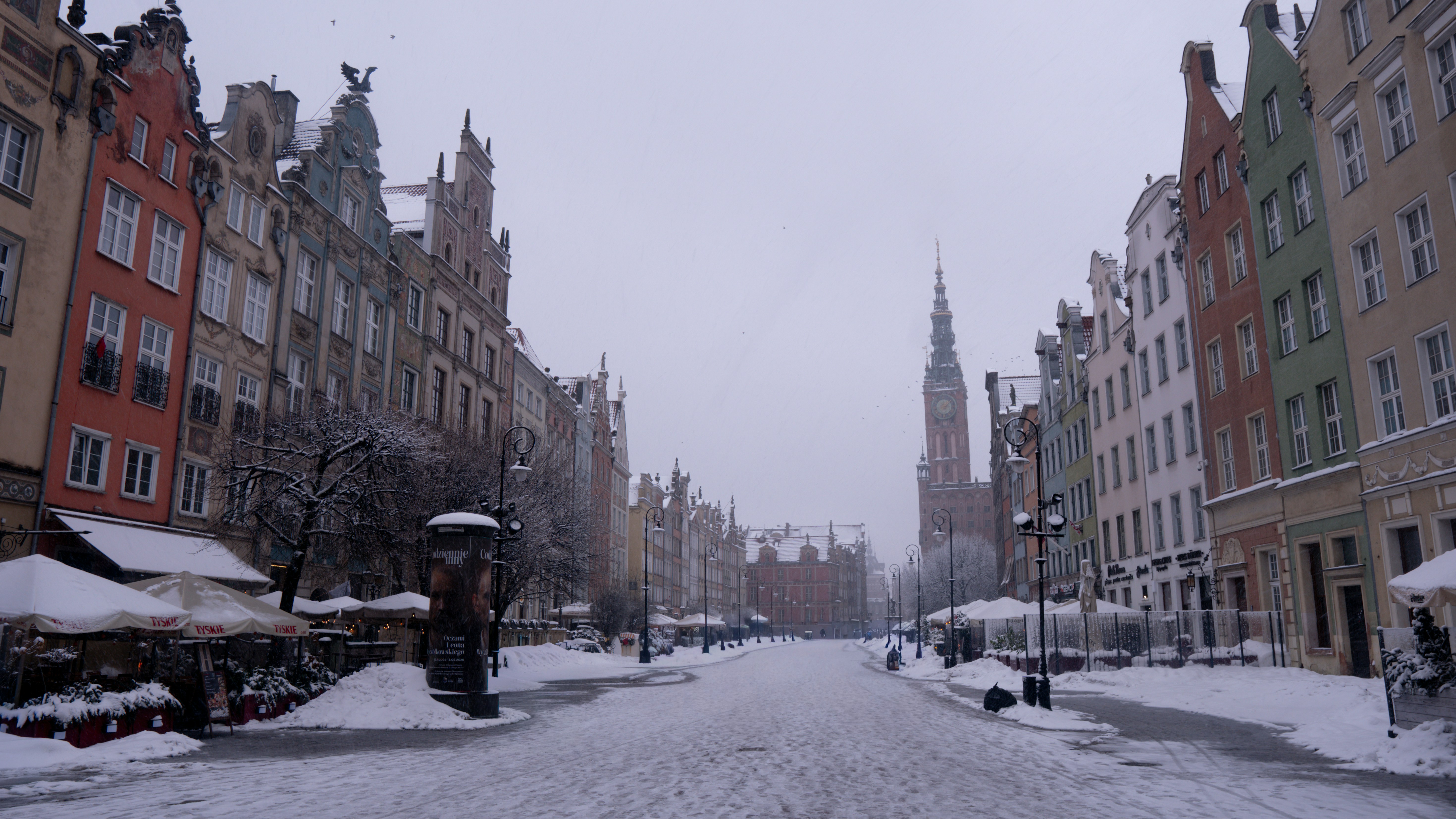Colorful buildings line a snowy street in winter.