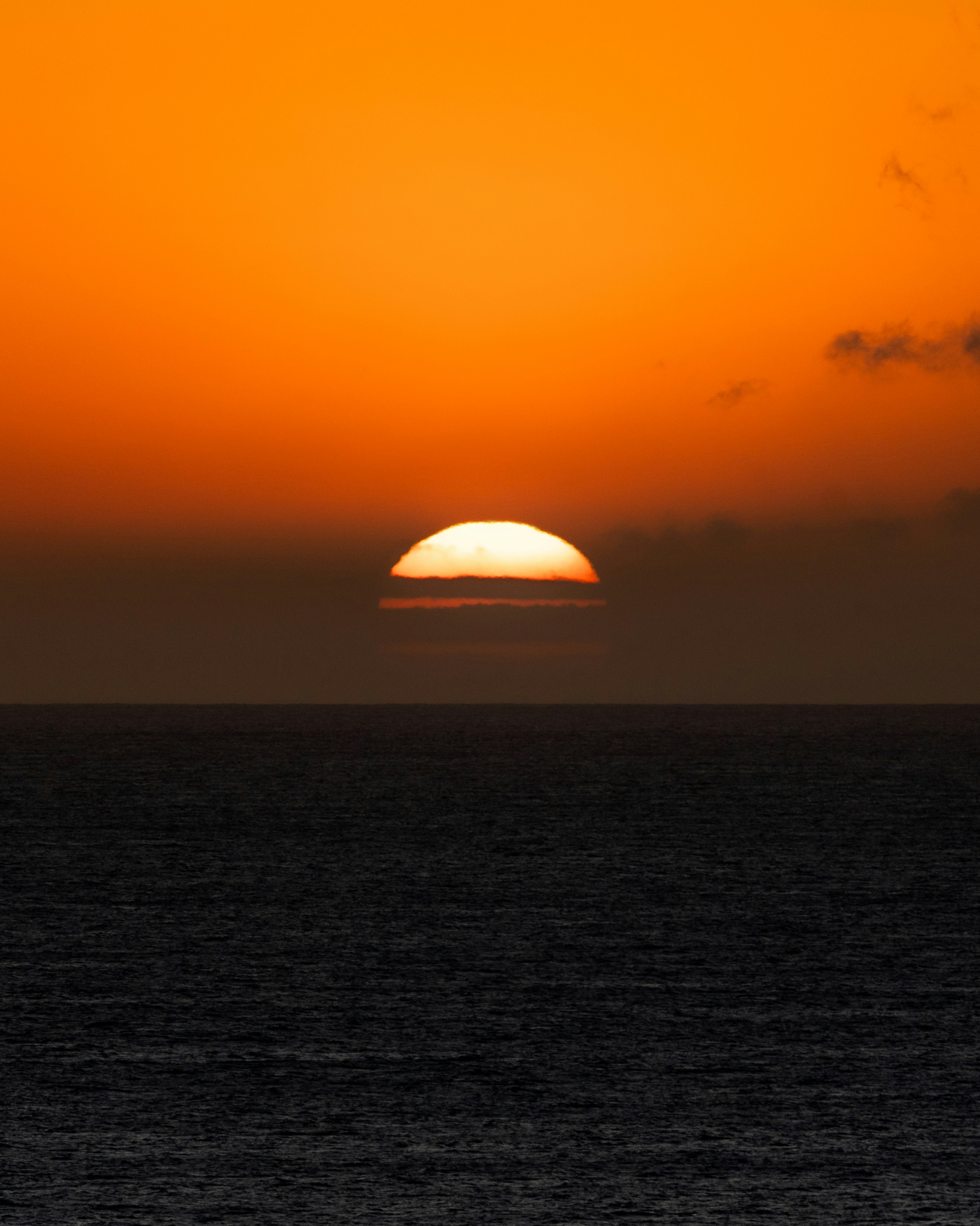 The sun setting over the dark ocean