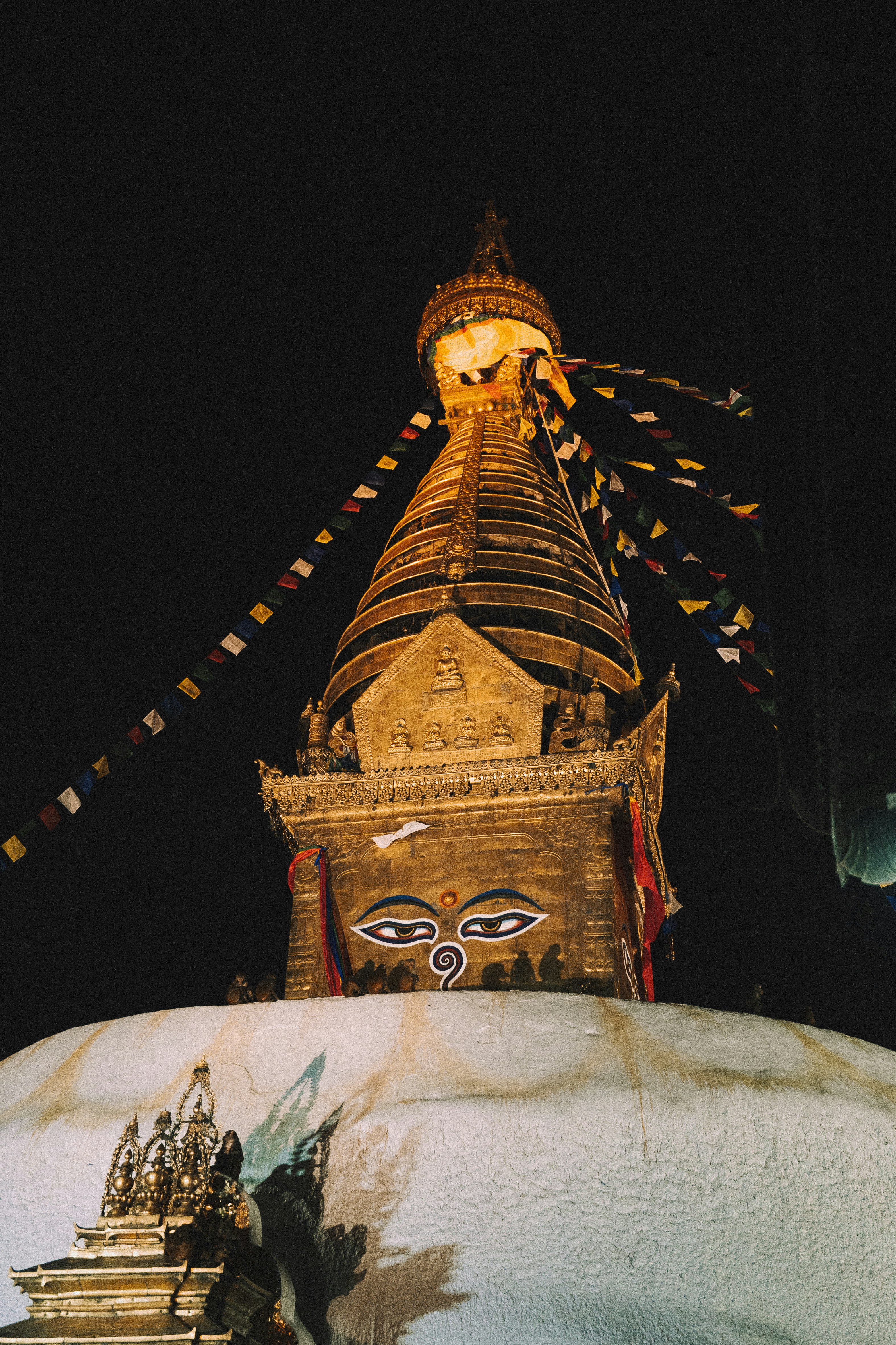 Goldene Stupa mit Gebetsfahnen in der Nacht