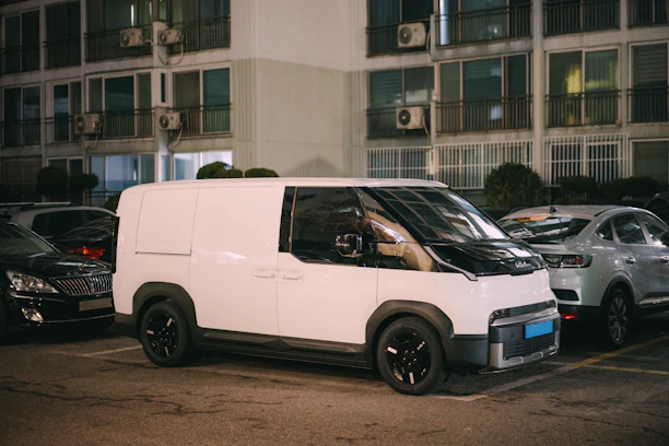 A white delivery van parked at night.