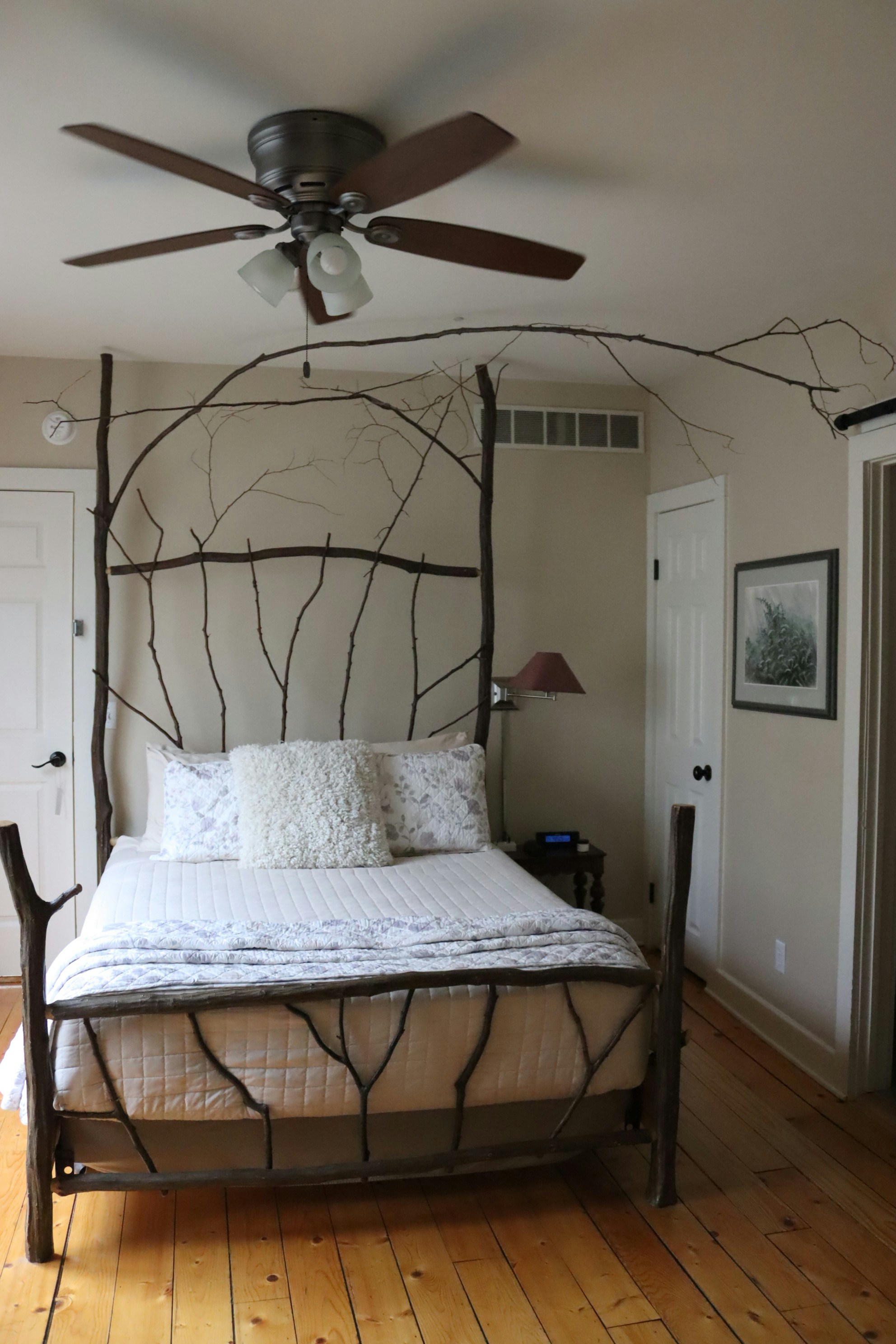 Rustic bed frame made of natural branches in a bedroom.