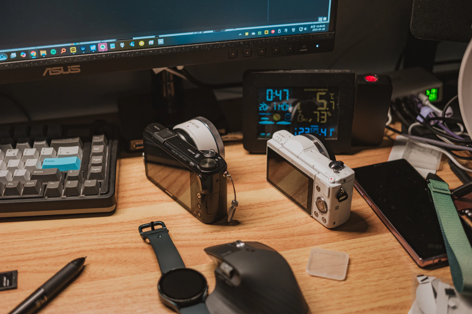 Keyboard, mouse, smartwatch and technology accessories arranged across a desk