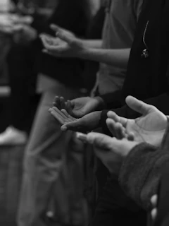 A group of people with open hands in prayer