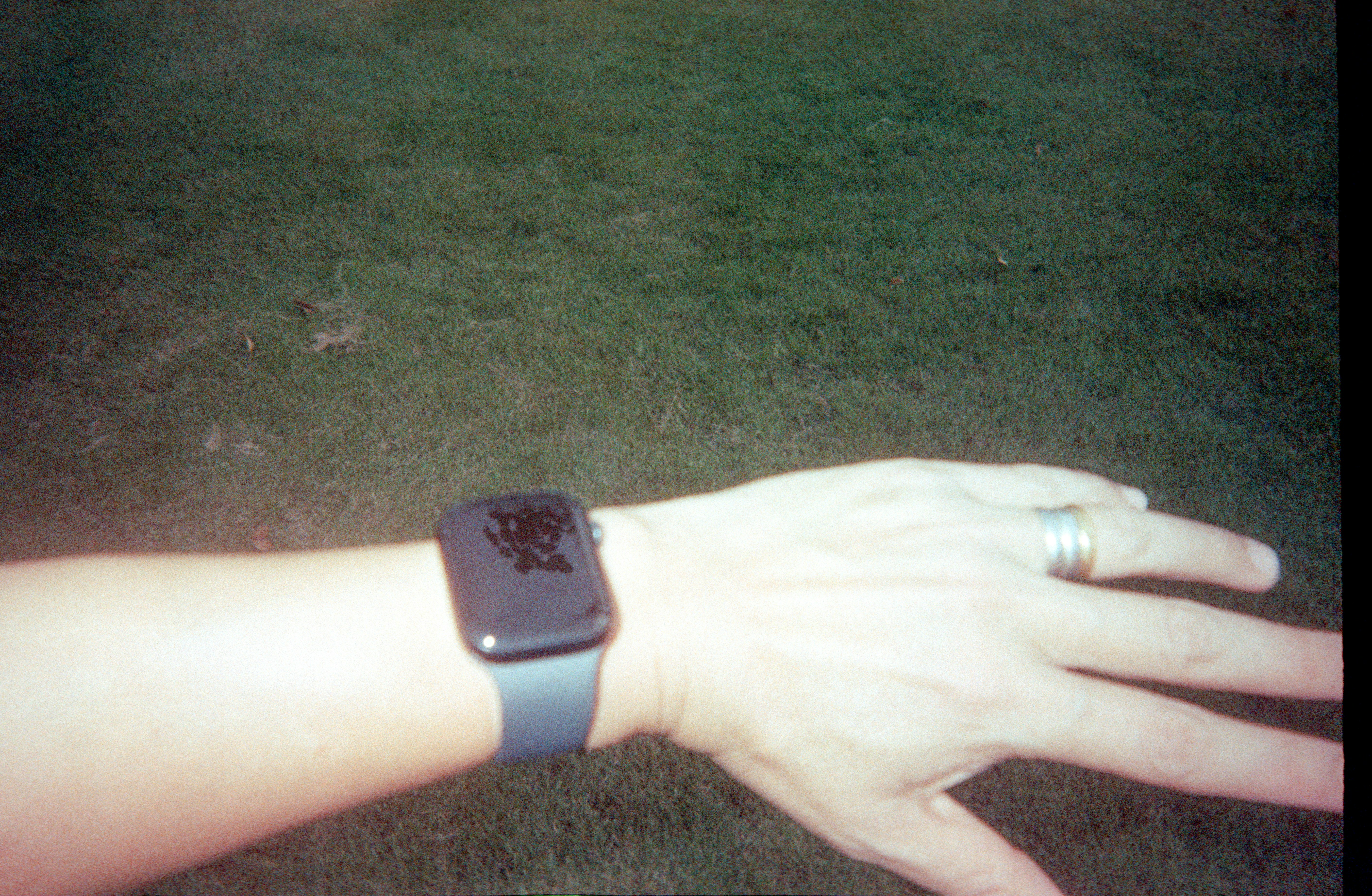 A wrist wearing a smartwatch with a dark screen.
