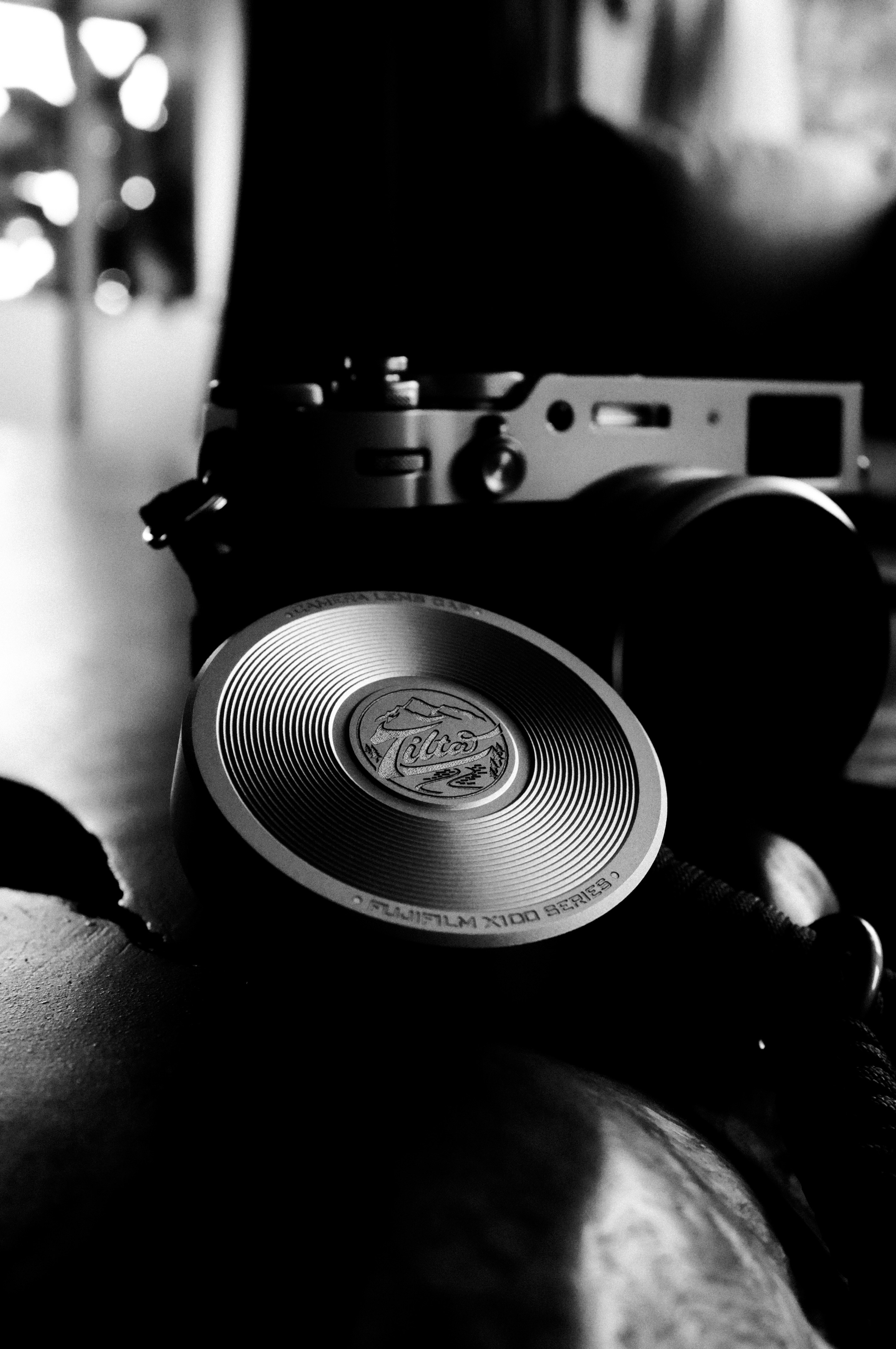 A vintage camera and lens cap on a wooden surface