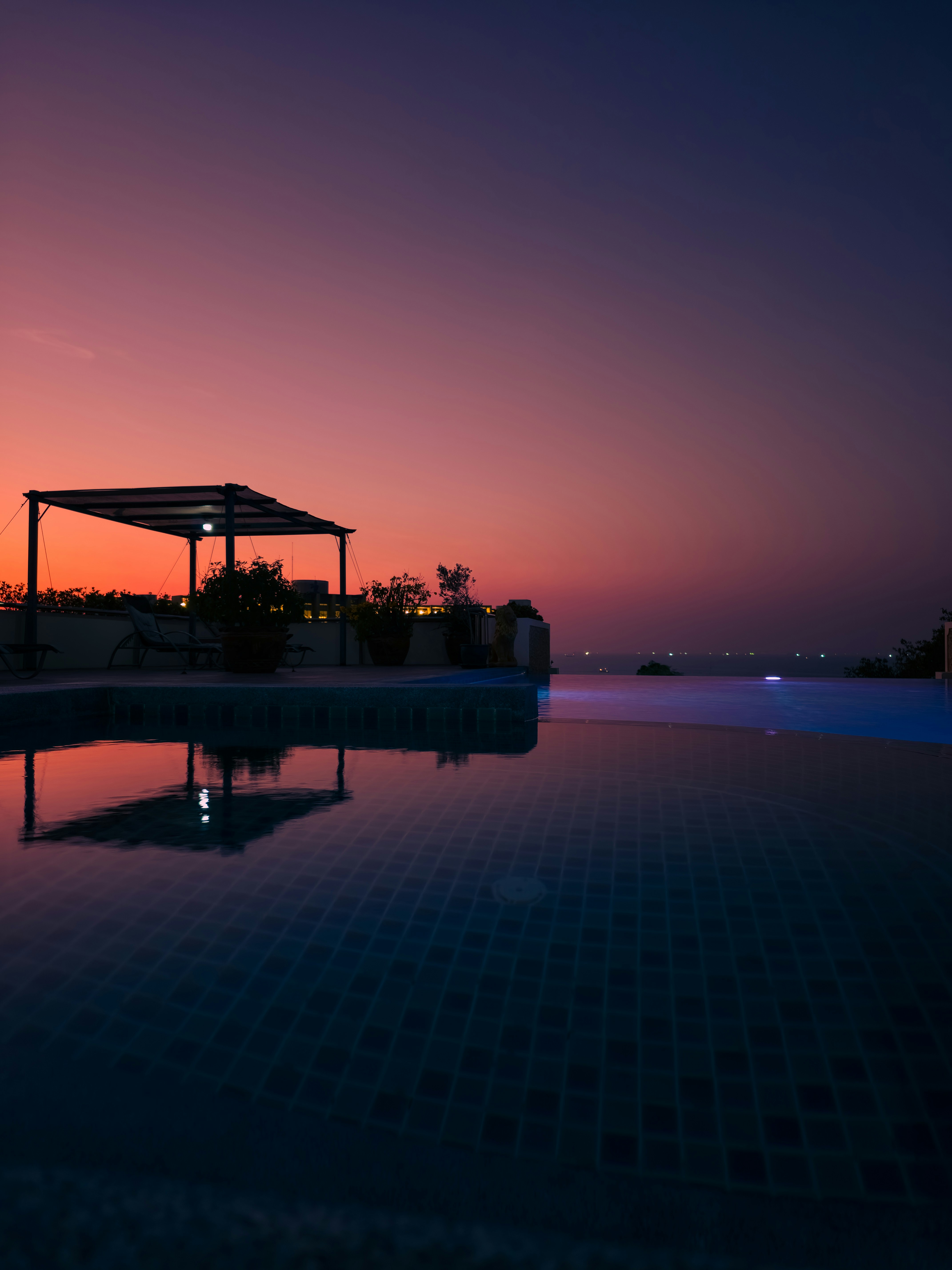 Infinity pool at sunset with purple sky