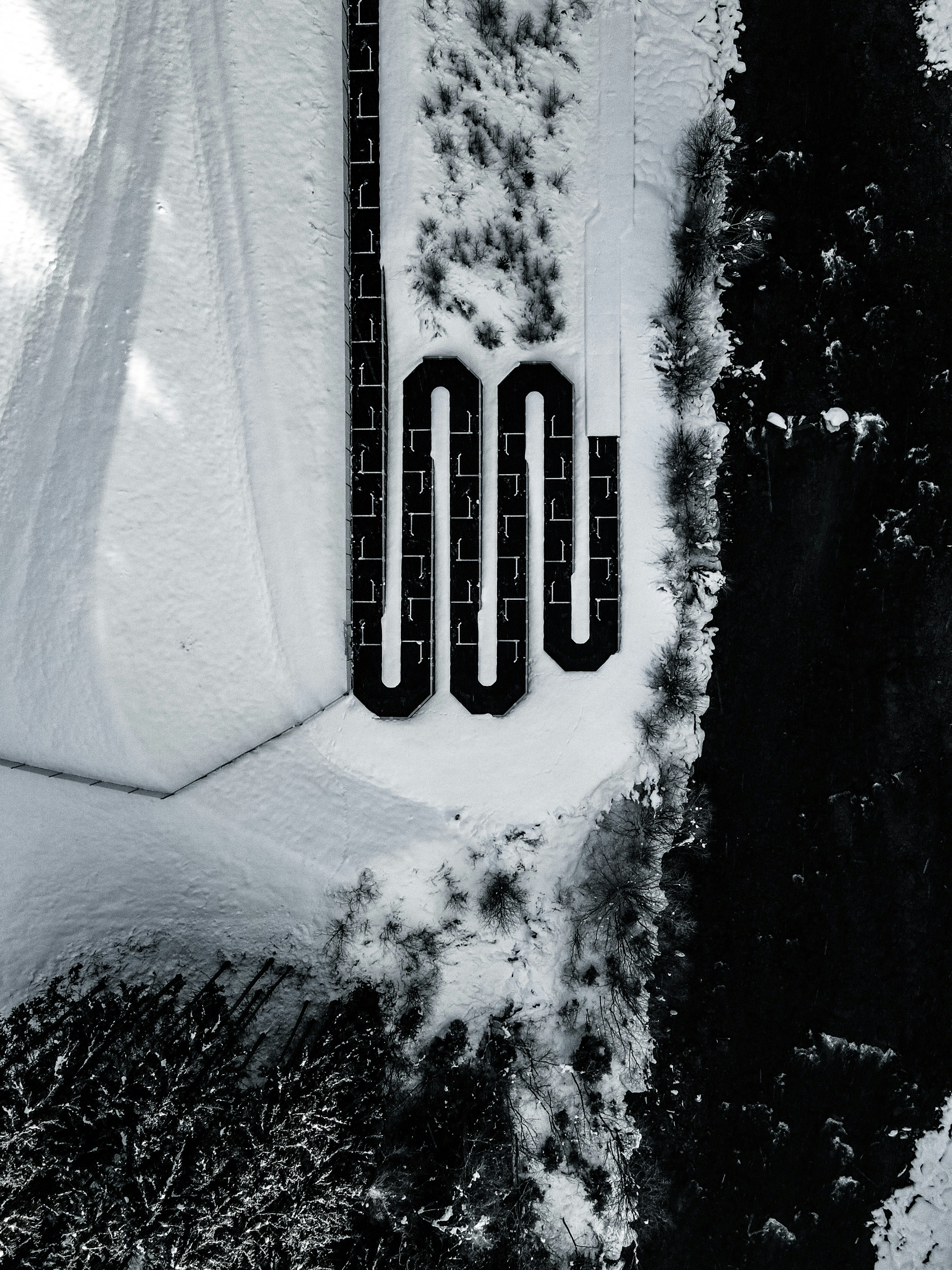 A winding path covered in snow with trees nearby