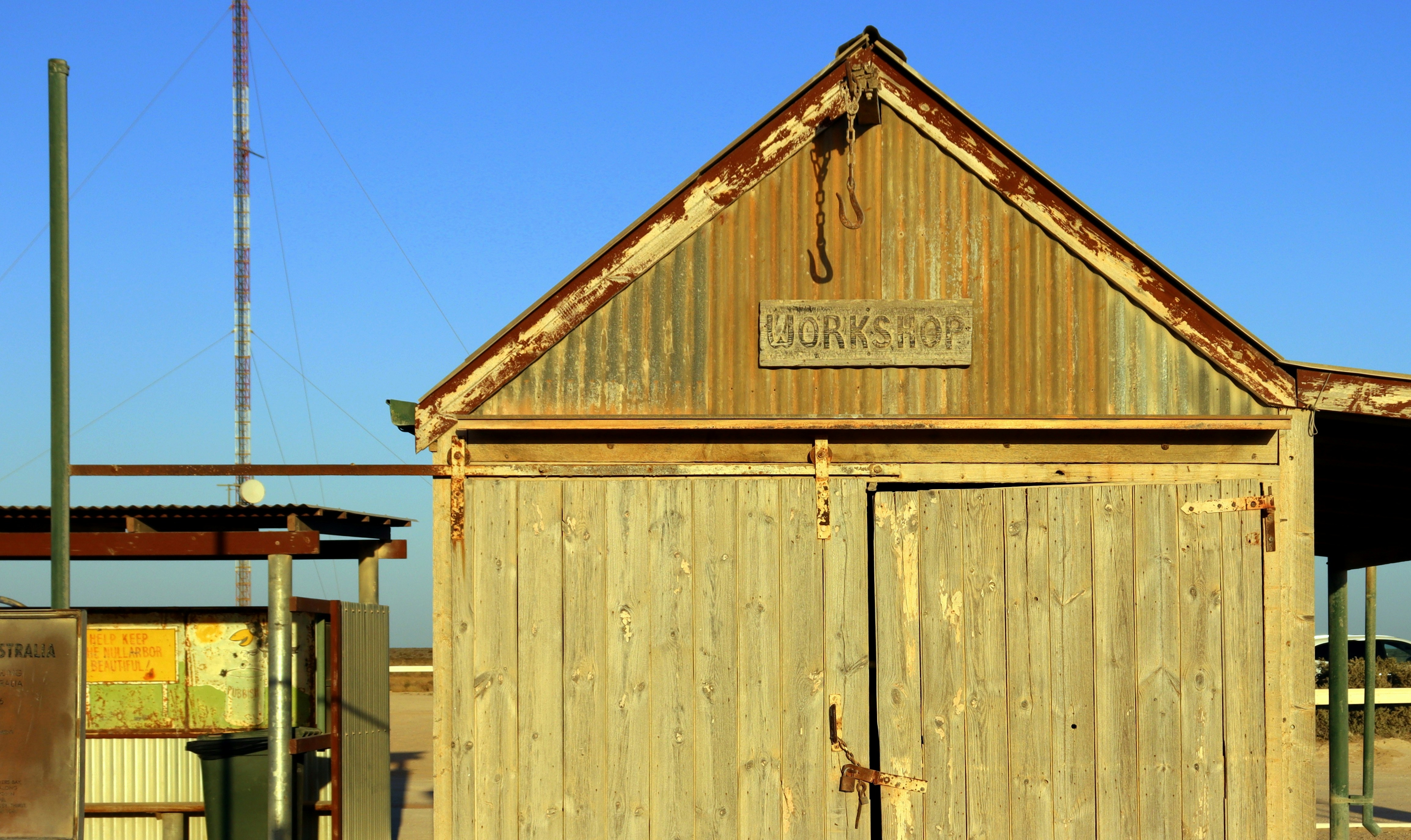 Old wooden shed with rusty roof and doors.