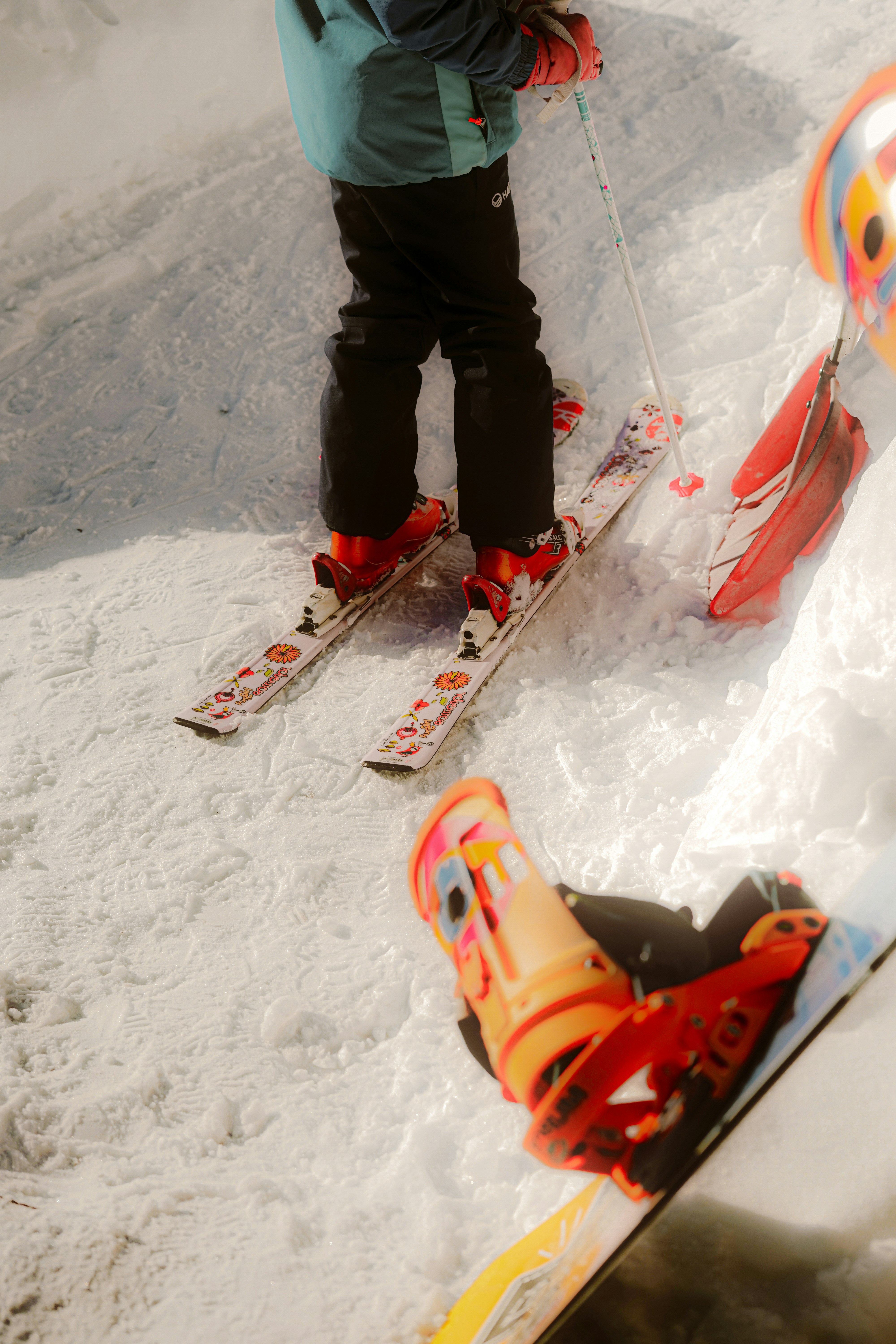 Two children on skis and snowboard in snow