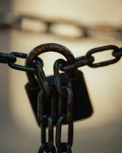 A rusty padlock on a thick metal chain — symbolizing the enduring tension between government authority and private property rights