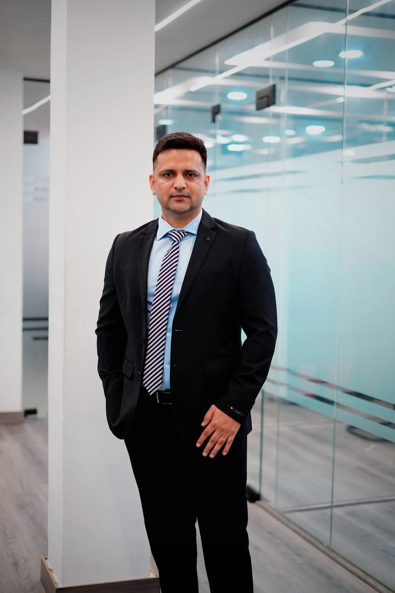An Indian retail chain owner in a modern glass-walled office