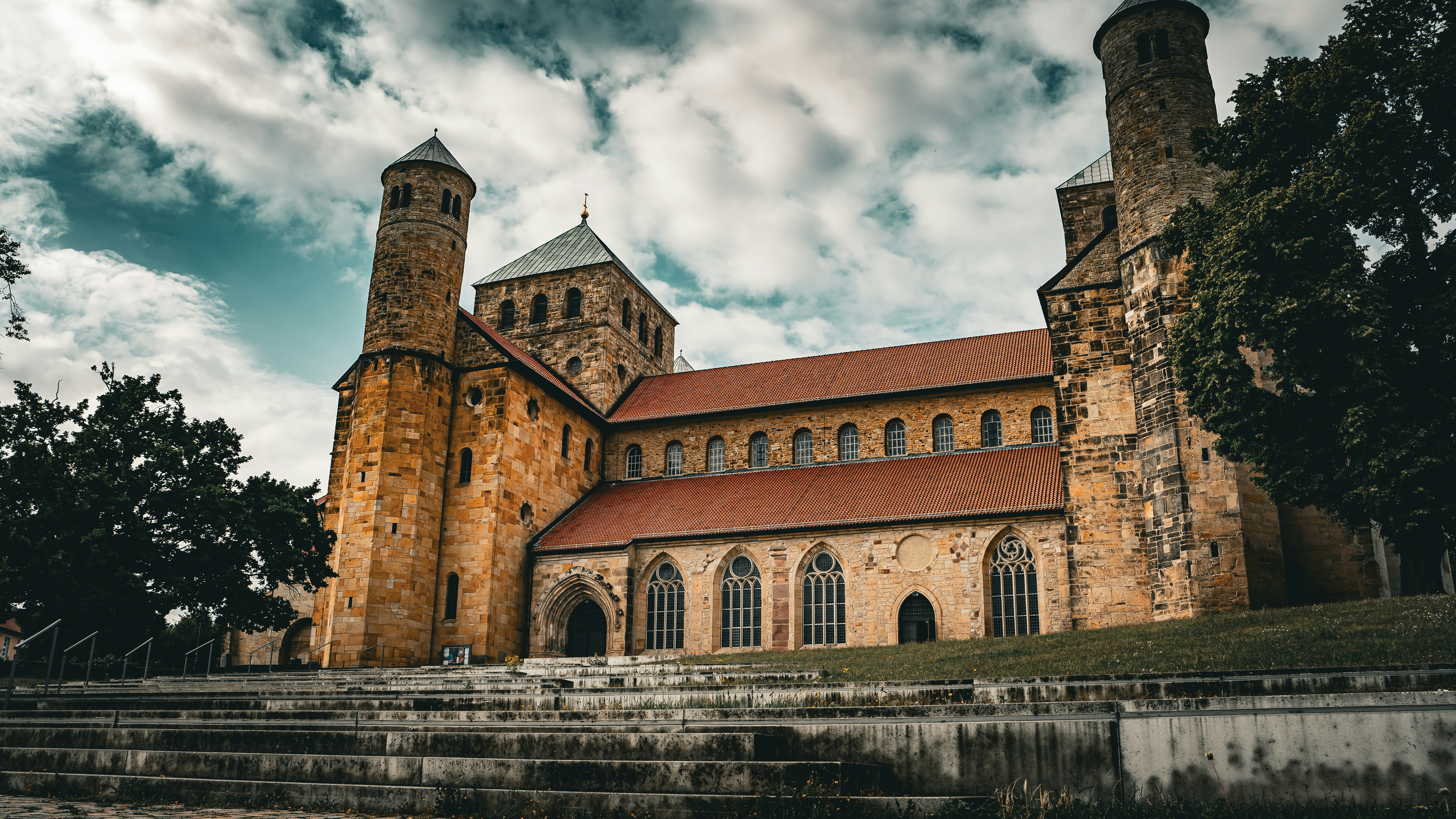 Historic stone church with tall towers under cloudy sky