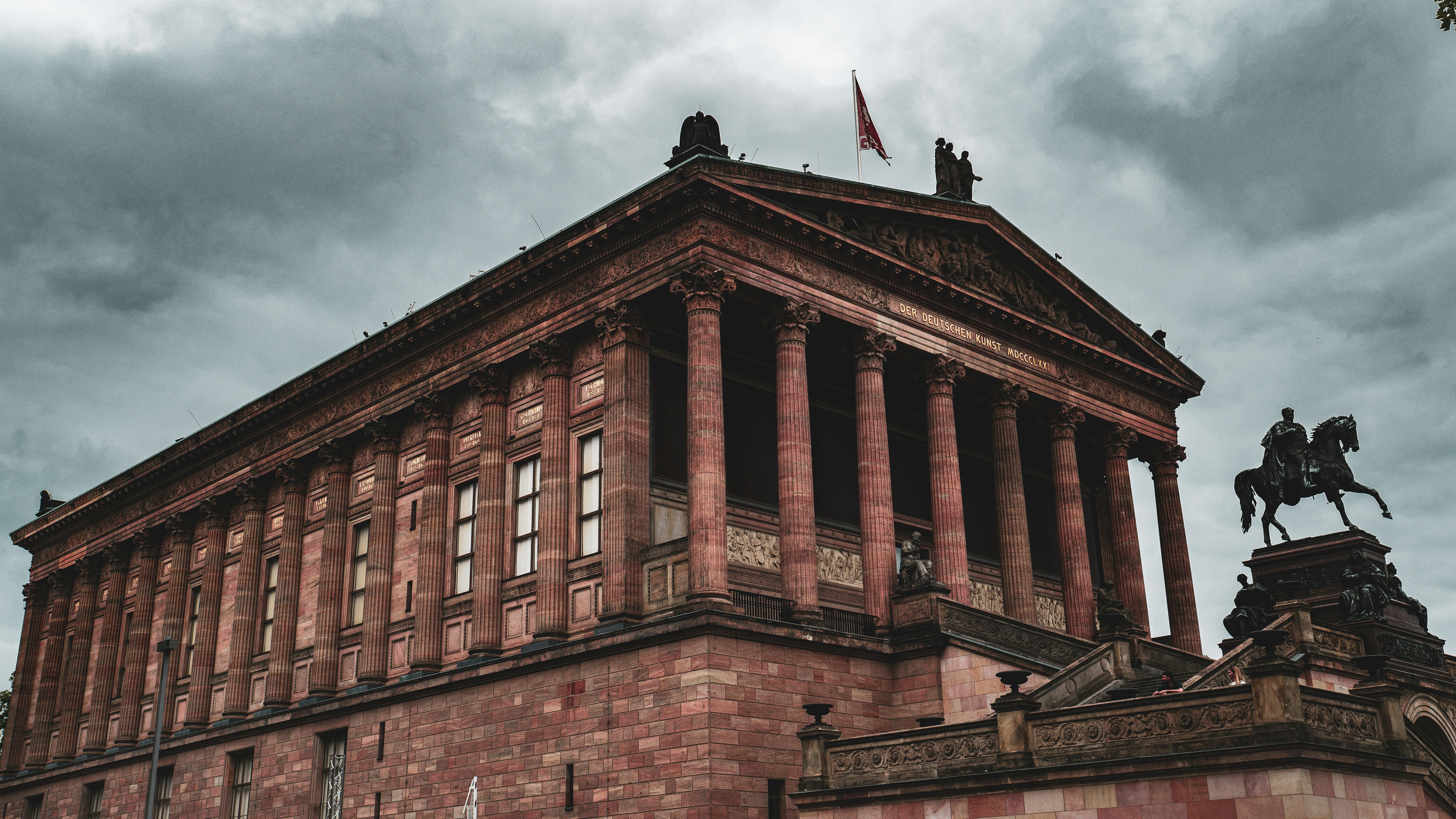 Neoclassical building with columns and equestrian statue.