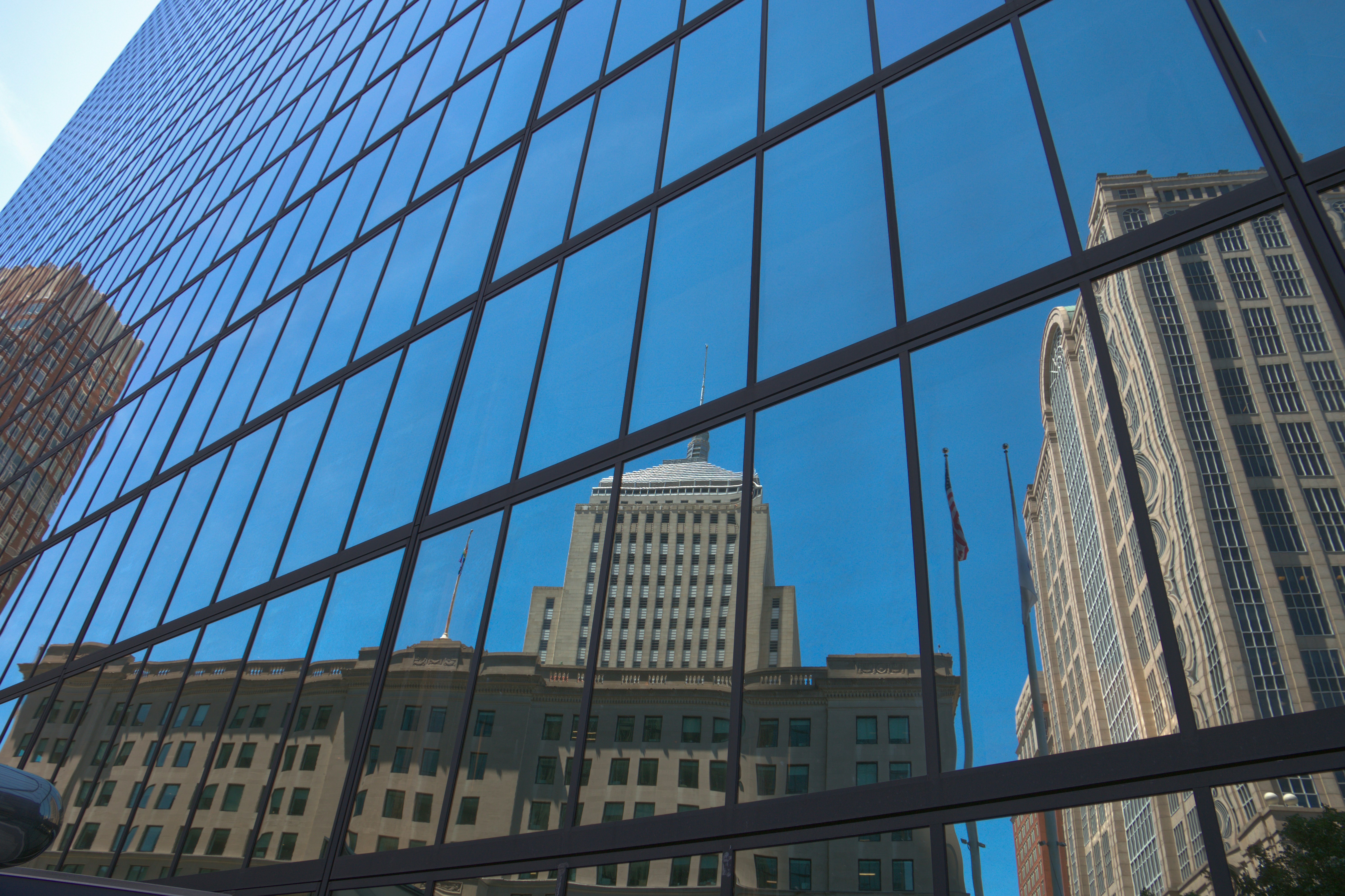Edificio moderno in vetro che riflette l'architettura storica