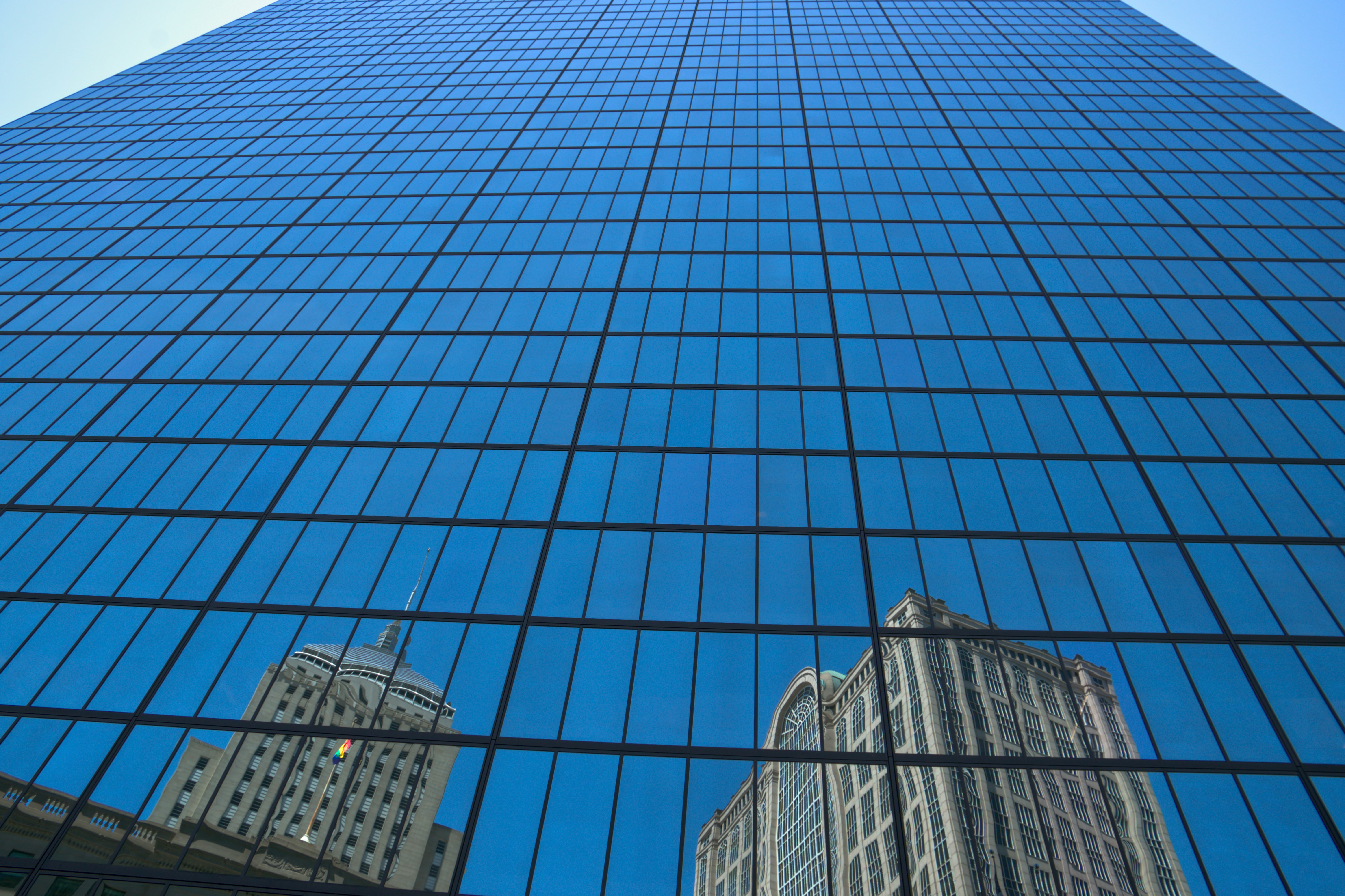 Grattacielo moderno con riflessi di edifici più vecchi.