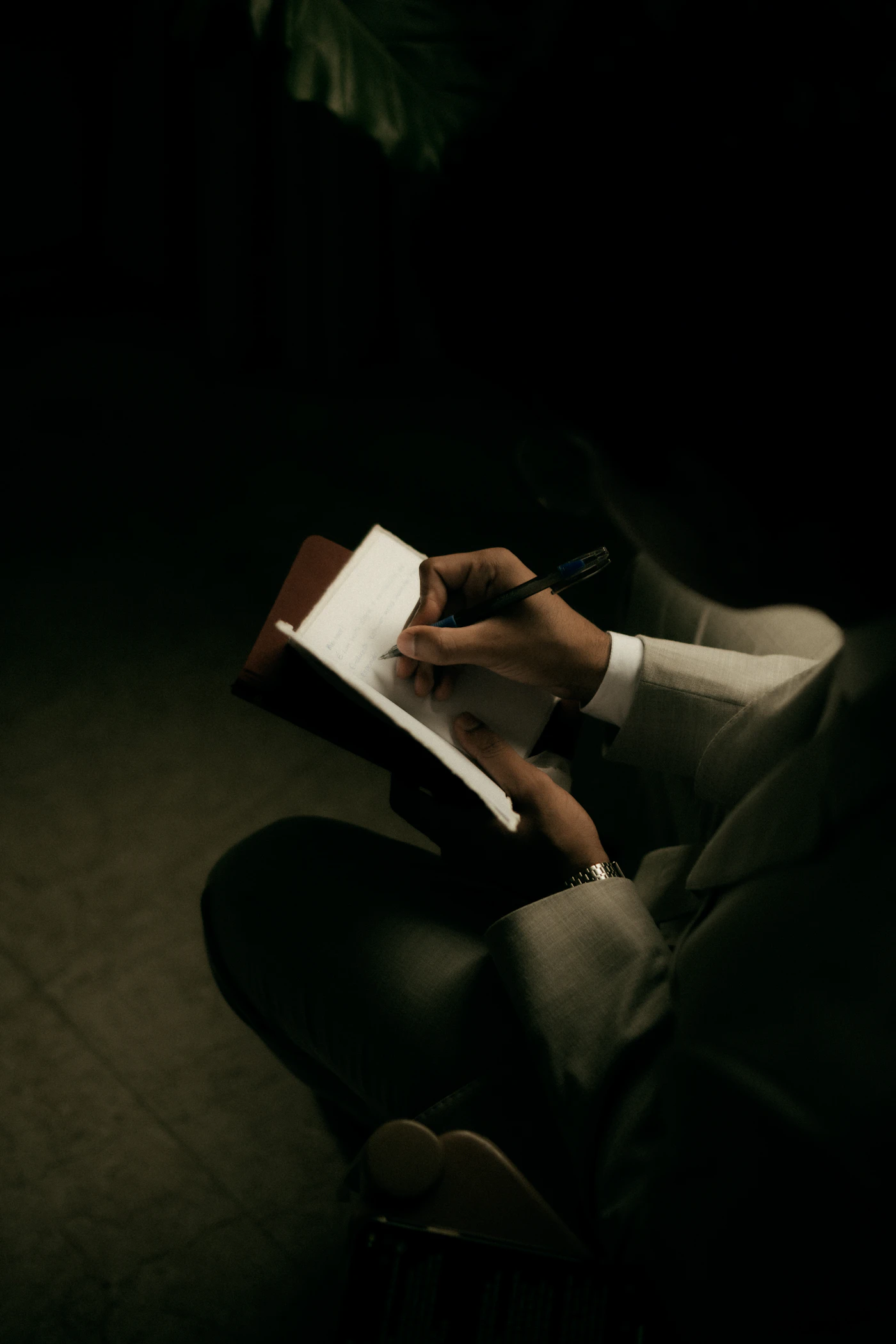 Person schreibt persönliche Gedanken und Fortschritte in ein Notizbuch