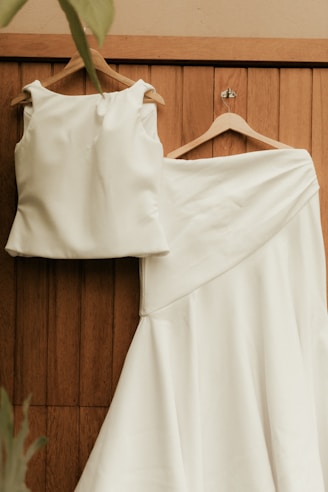White top and skirt hanging on wooden door