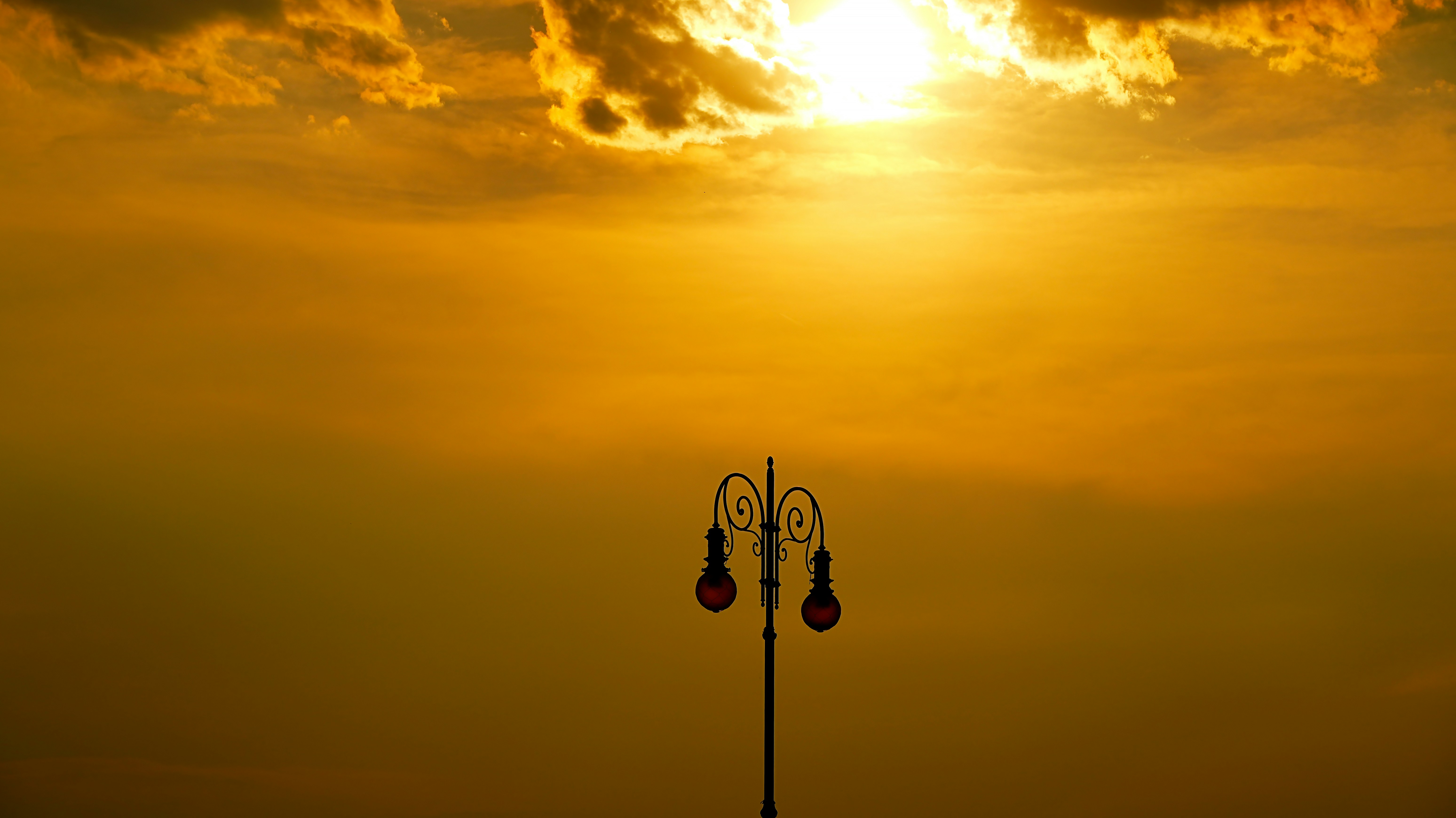 Straßenlaterne vor einem dramatischen Sonnenuntergangshimmel
