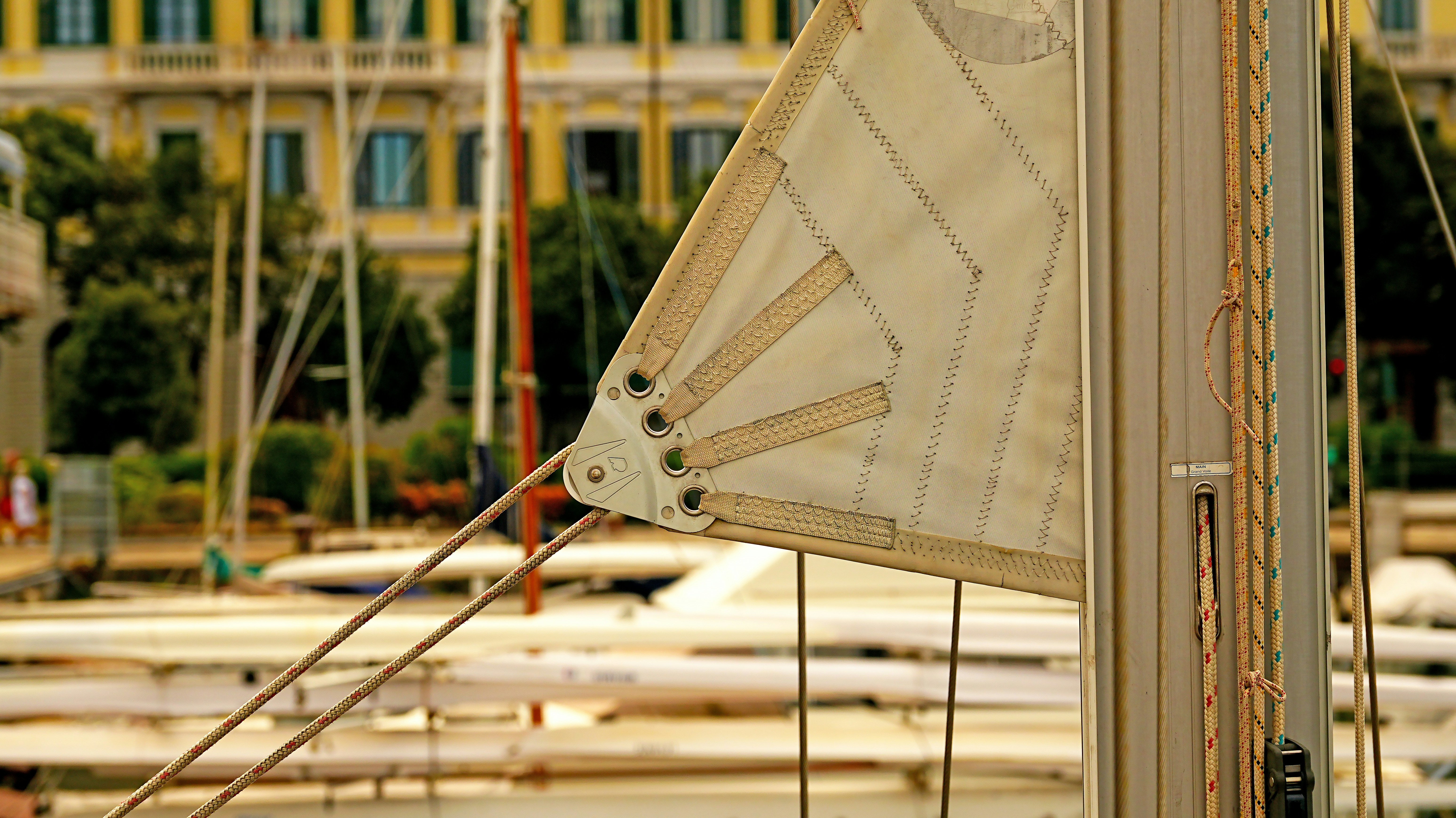Segelboot mit Masten und Gebäuden im Hintergrund