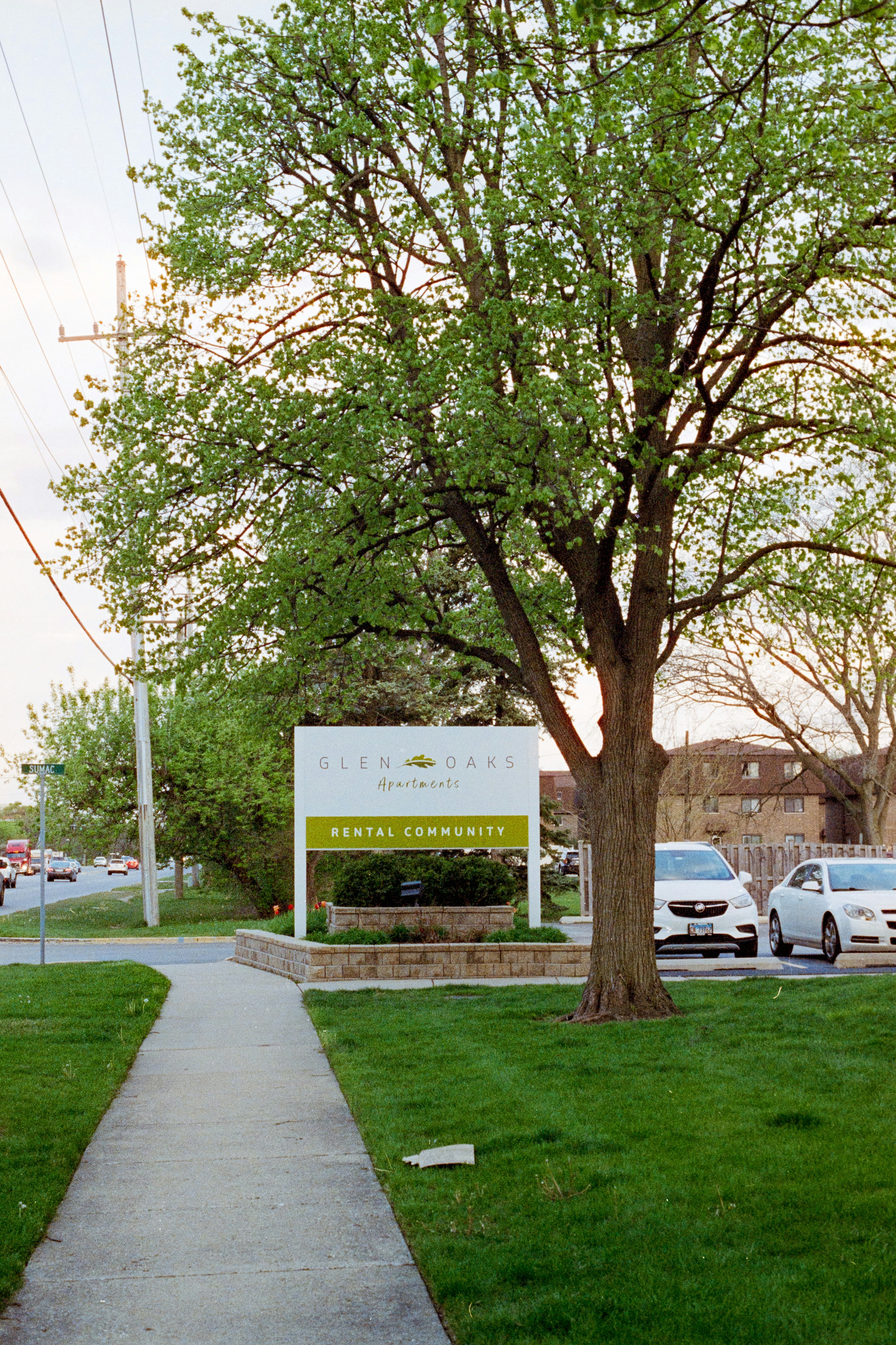 Glen oaks dental community sign with cars and trees.