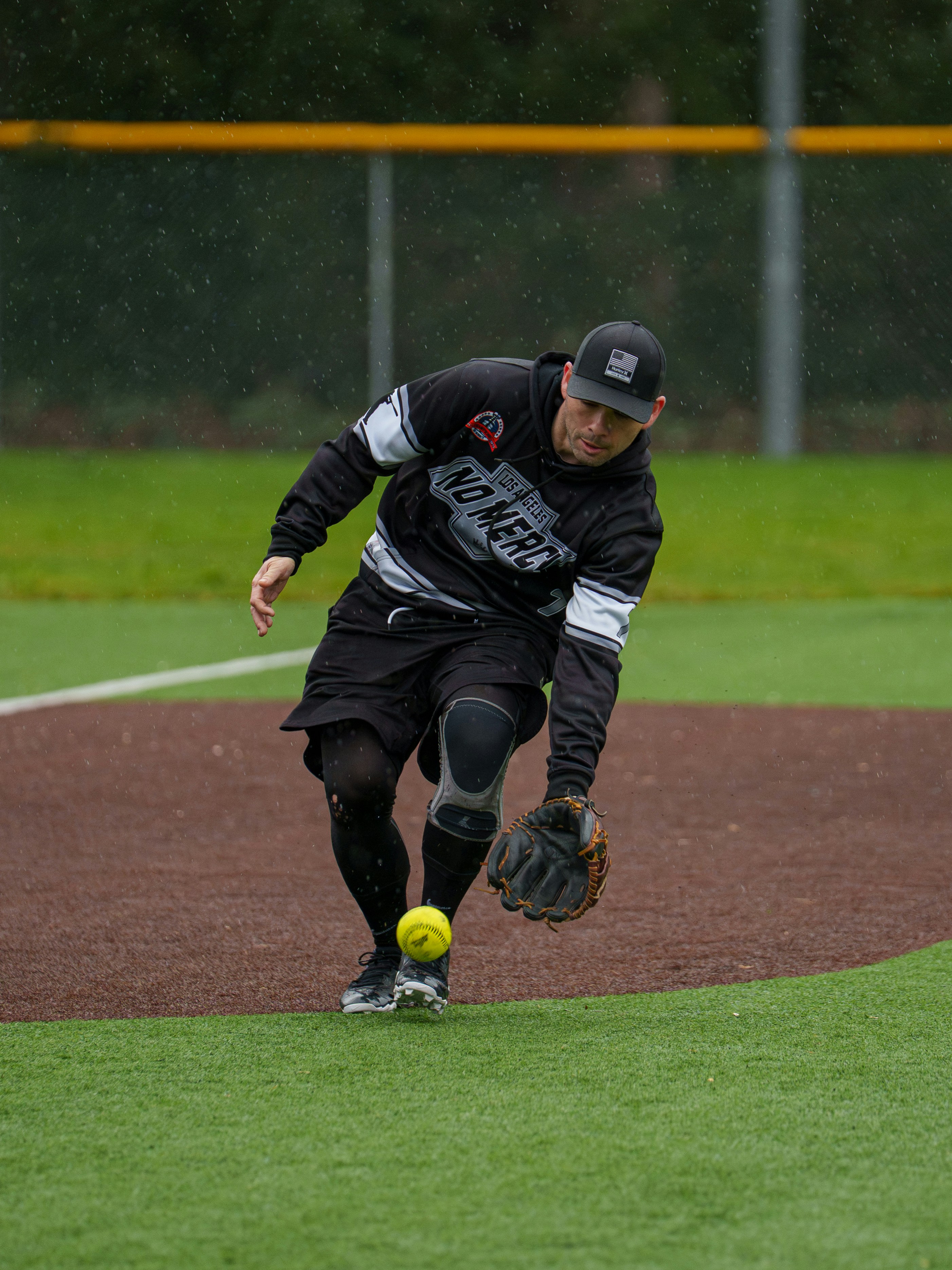 A man in athletic wear catching a softball