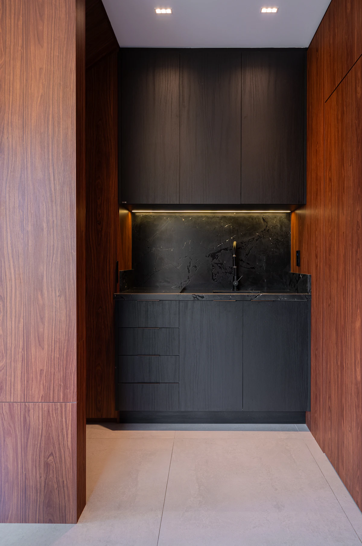 Walnut and matte black for a Corktown condo — every panel cut from one board for grain match