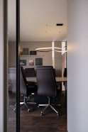 Modern conference room with leather chairs and table.