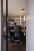 Modern conference room with leather chairs and table.