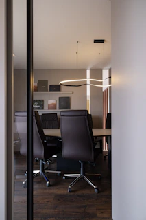 Modern conference room with leather chairs and table.
