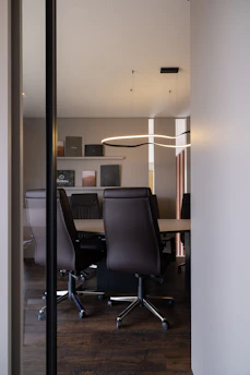 Modern conference room with leather chairs and table.