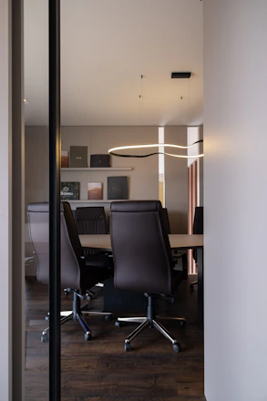 Modern conference room with leather chairs and table.