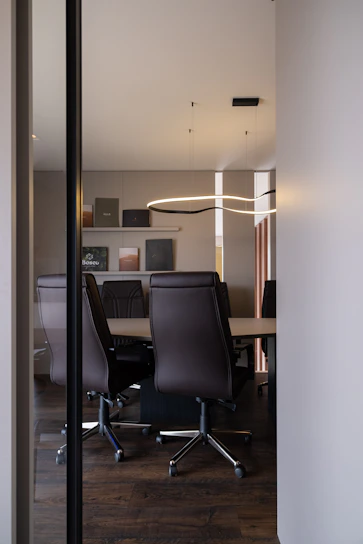 Modern conference room with leather chairs and table.