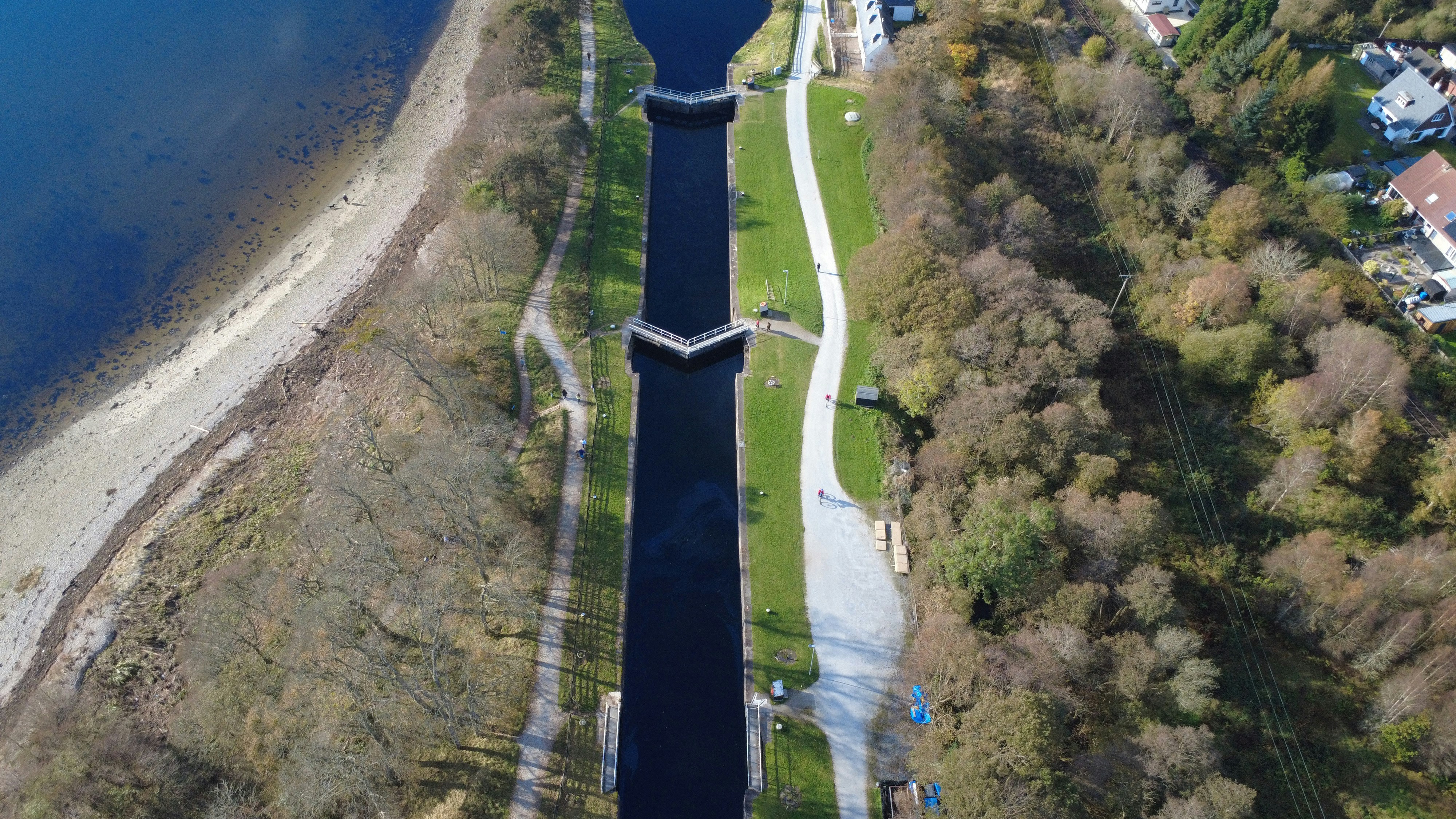 Aerial view of a canal with trees and a path