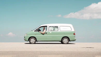 Man driving a mint green van on a sunny day