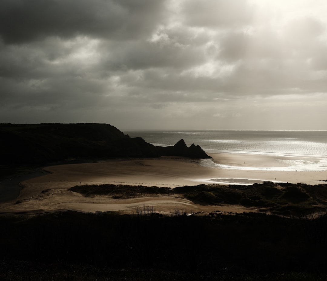 Dramatic cloudy sky over a serene beach landscape.