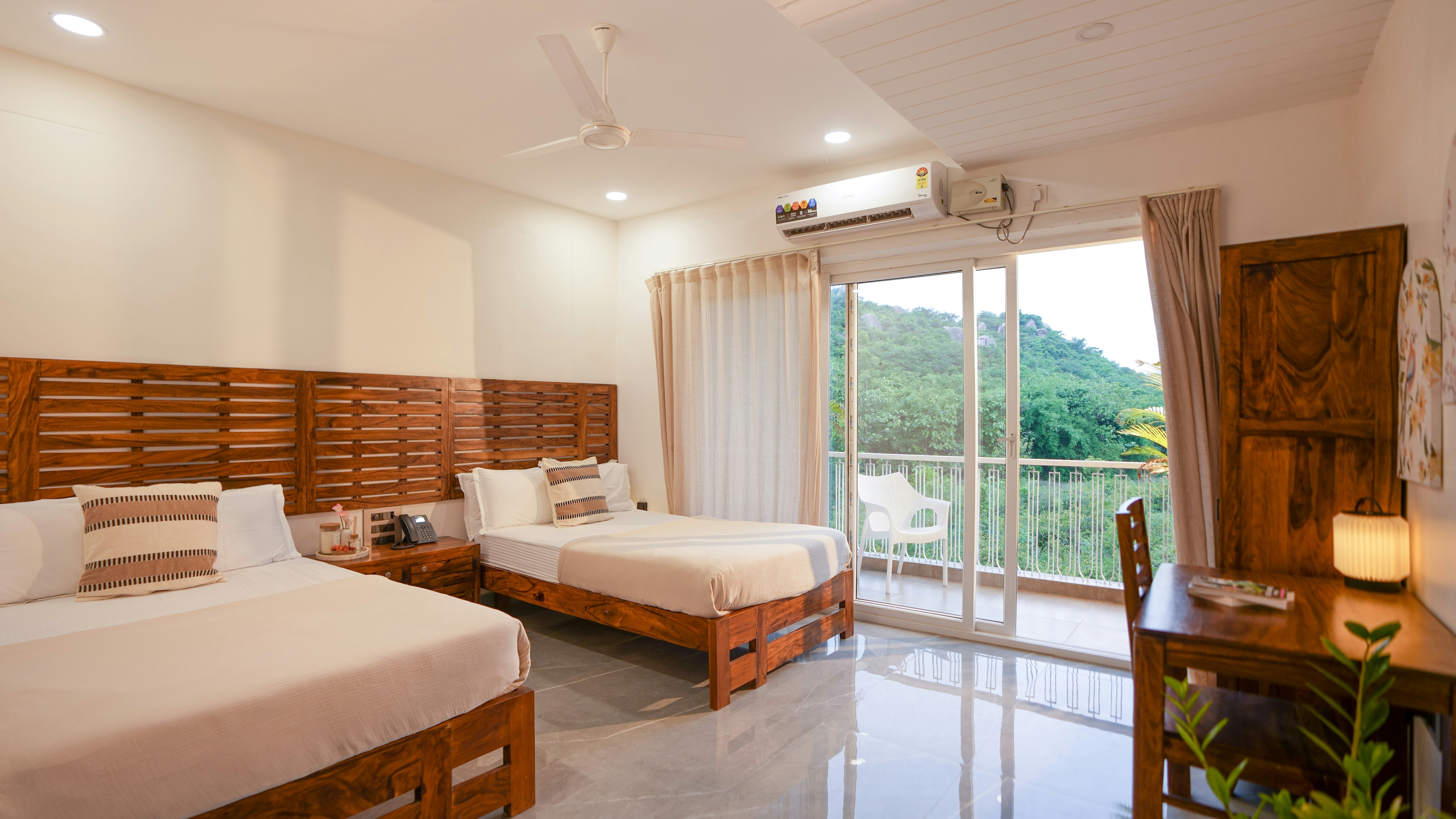Two beds in a hotel room with a balcony view