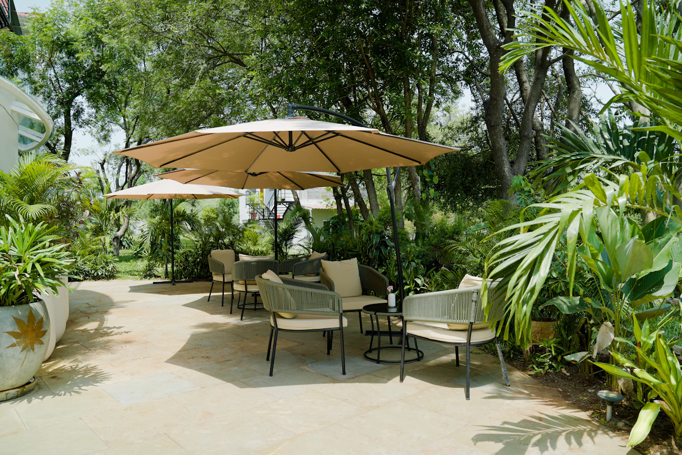 Bright outdoor patio with seating area and lush garden greenery