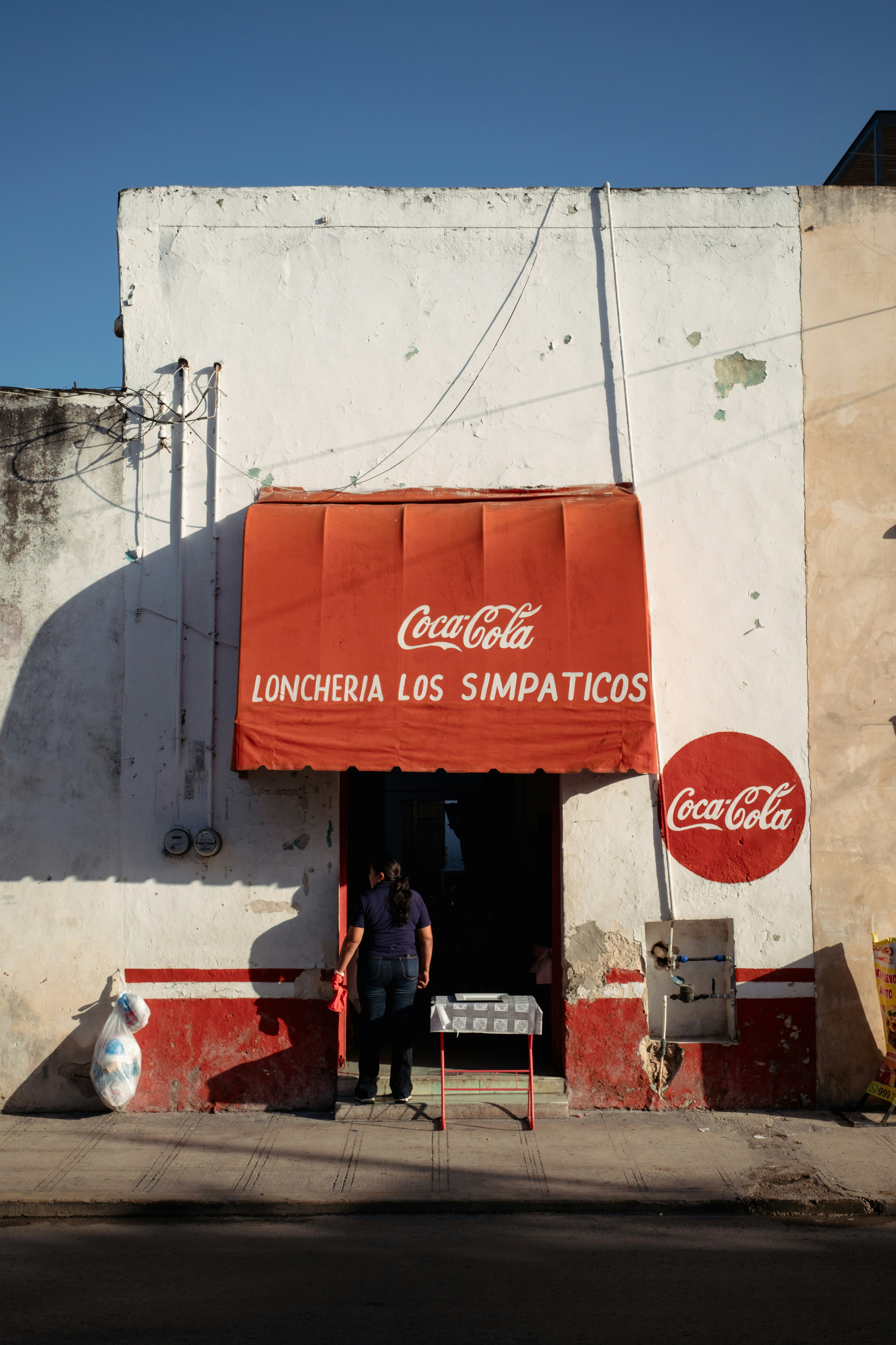 Una persona está en el umbral de una pequeña tienda.