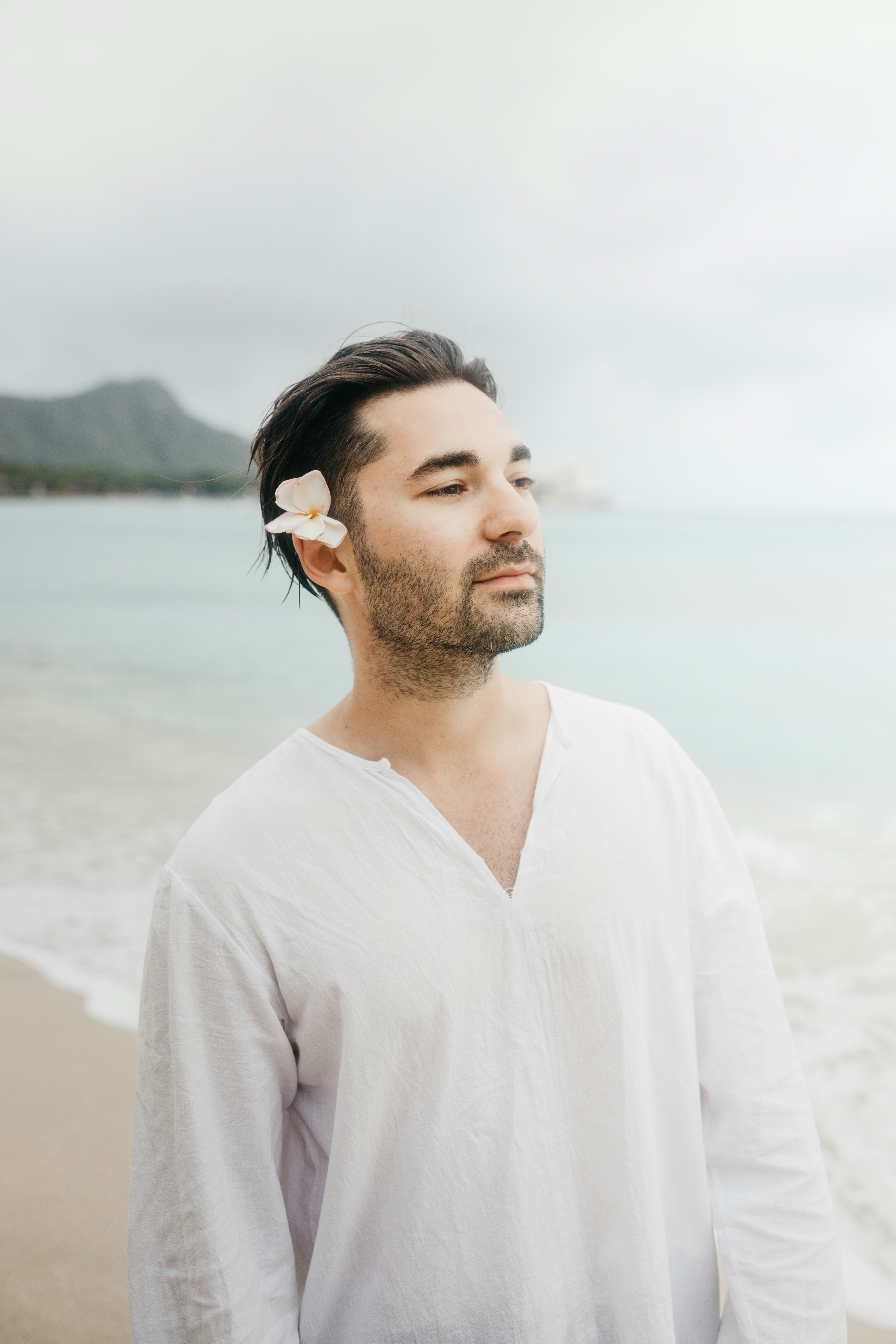 Homme avec une fleur dans les cheveux sur la plage