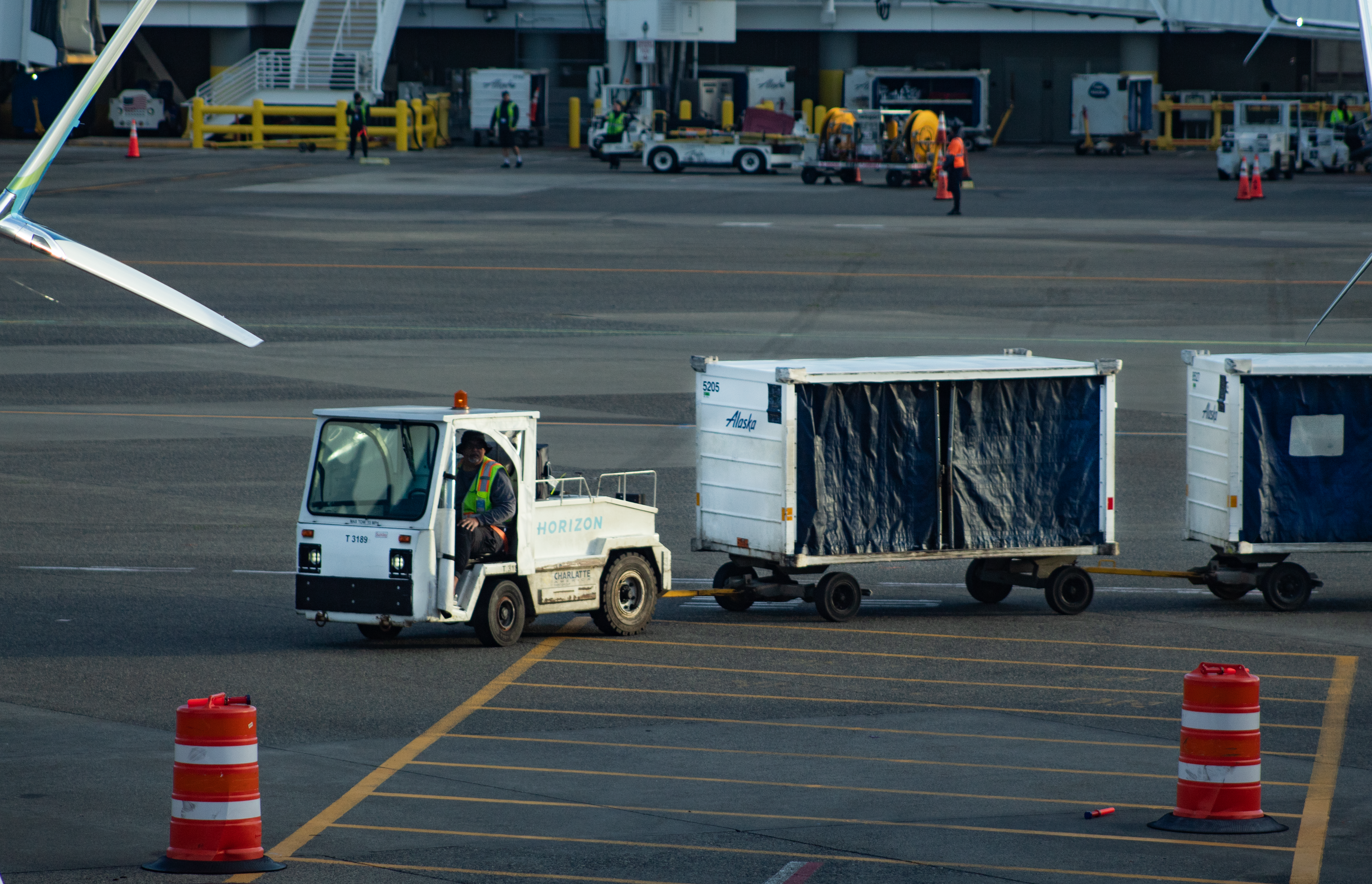 Tug pulls baggage carts across airport tarmac