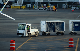 Tug pulls baggage carts across airport tarmac