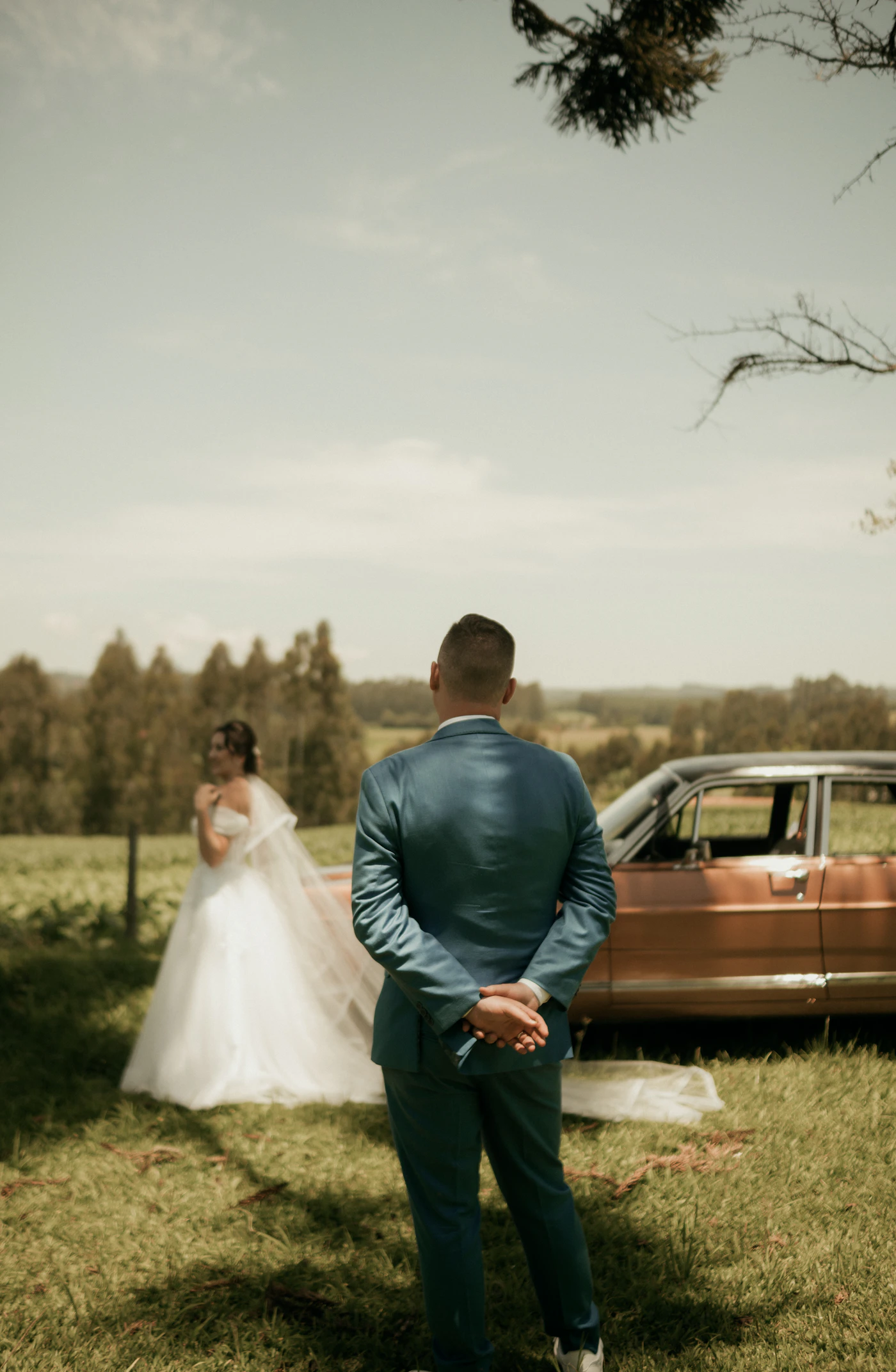 Couple in elopement ceremony attire arriving at a Prince Edward County vineyard for their elopement session with the pastoral Ontario wine country visible around them
