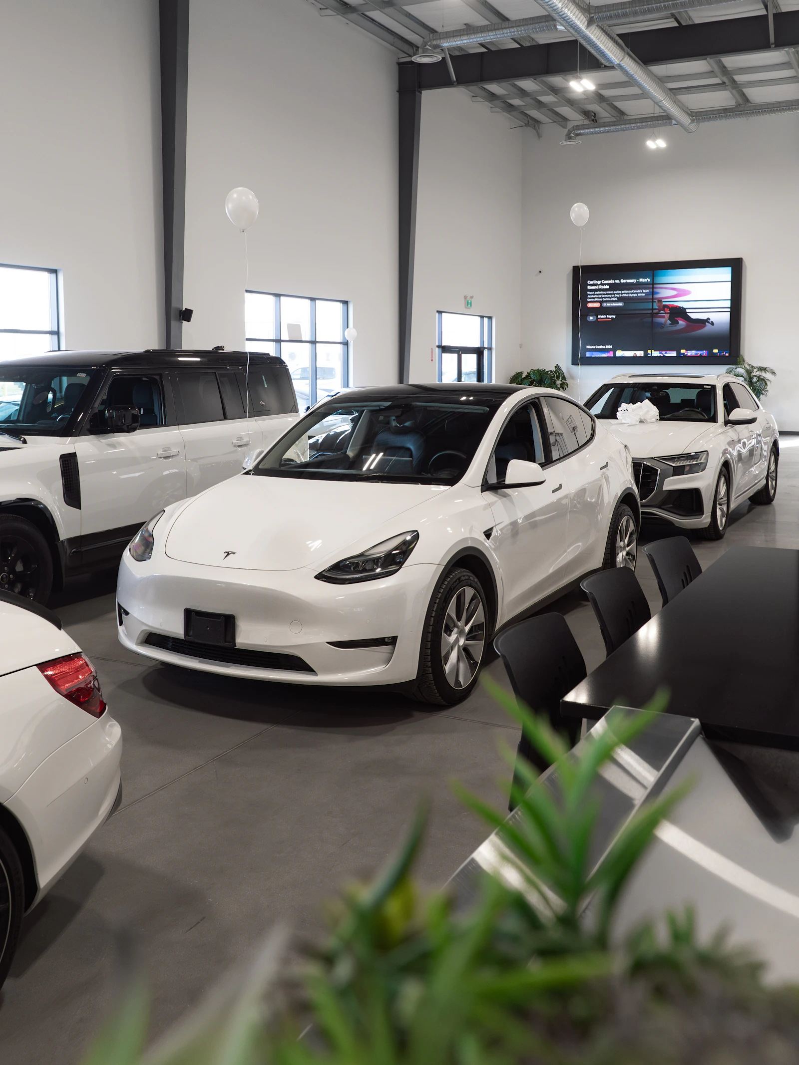 White Tesla Model Y in a modern showroom