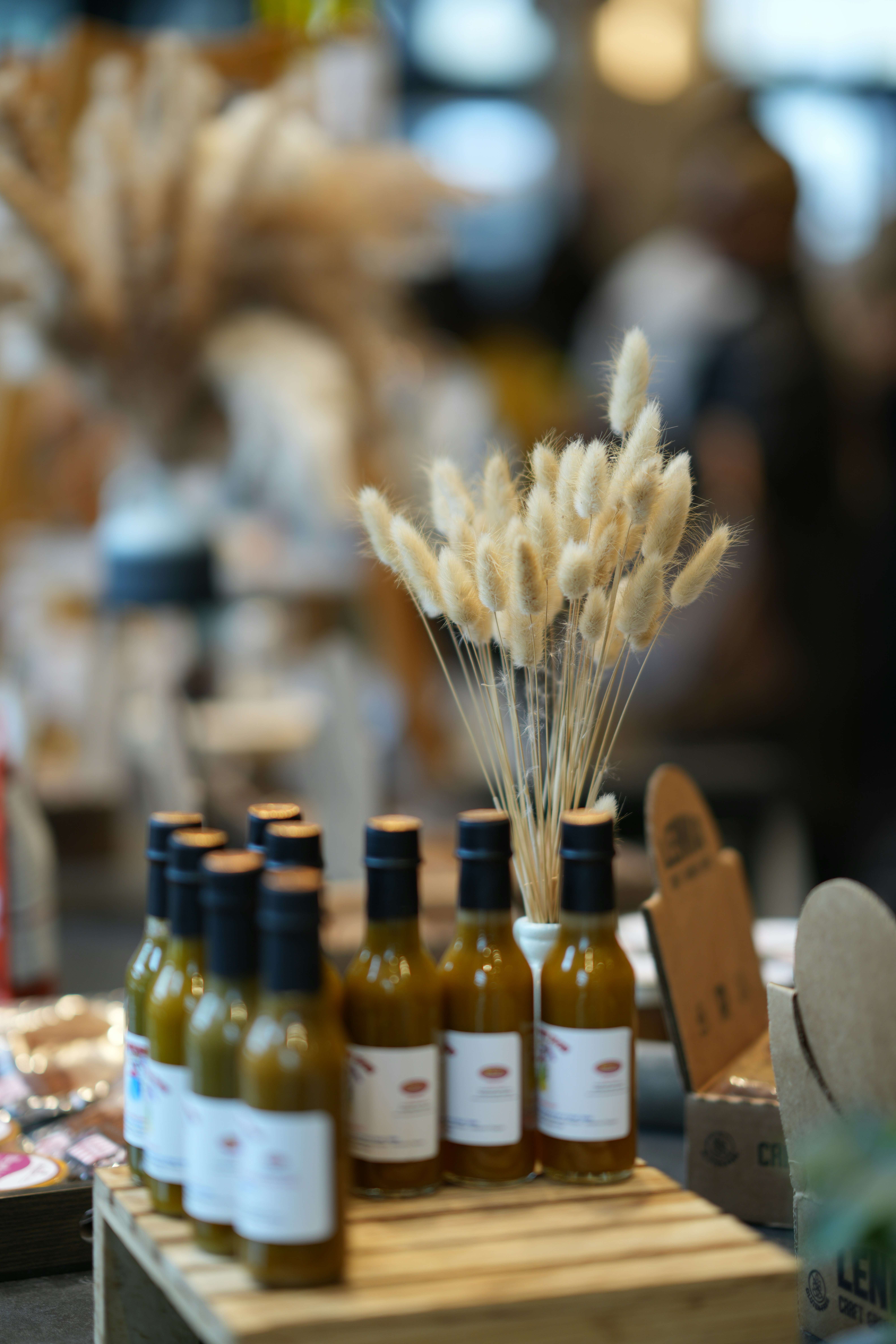 Bottles of sauce with dried flowers in background.