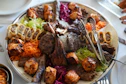 A large platter of assorted grilled meats and vegetables.